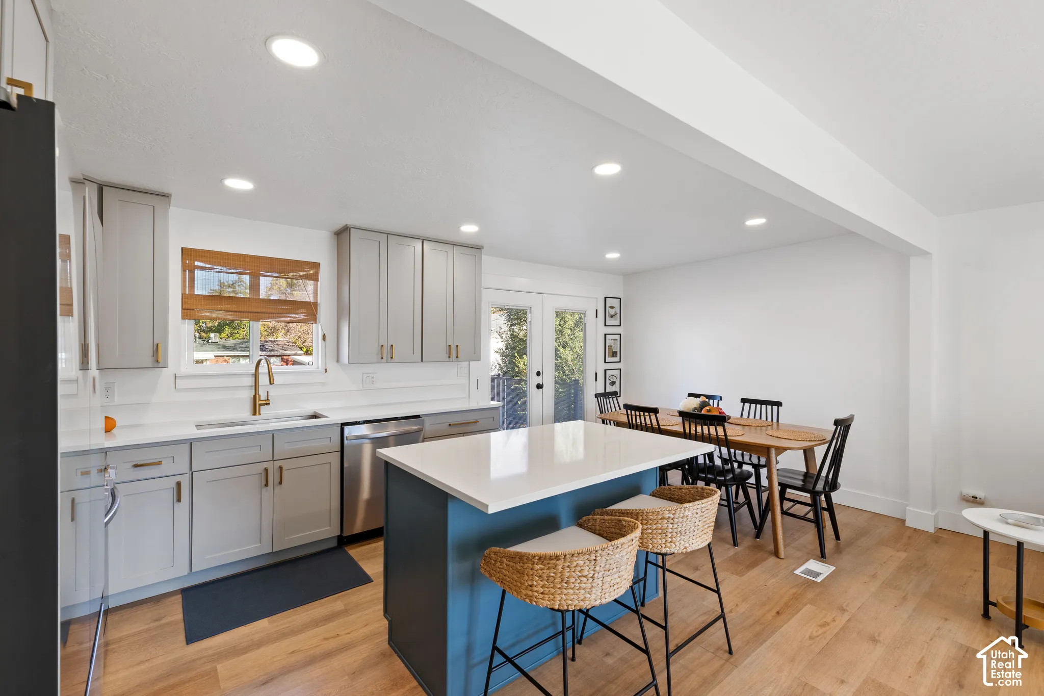 Kitchen featuring grey cabinetry, a contrasting center island with a quartz countertop, recessed lighting, and wood-finish flooring