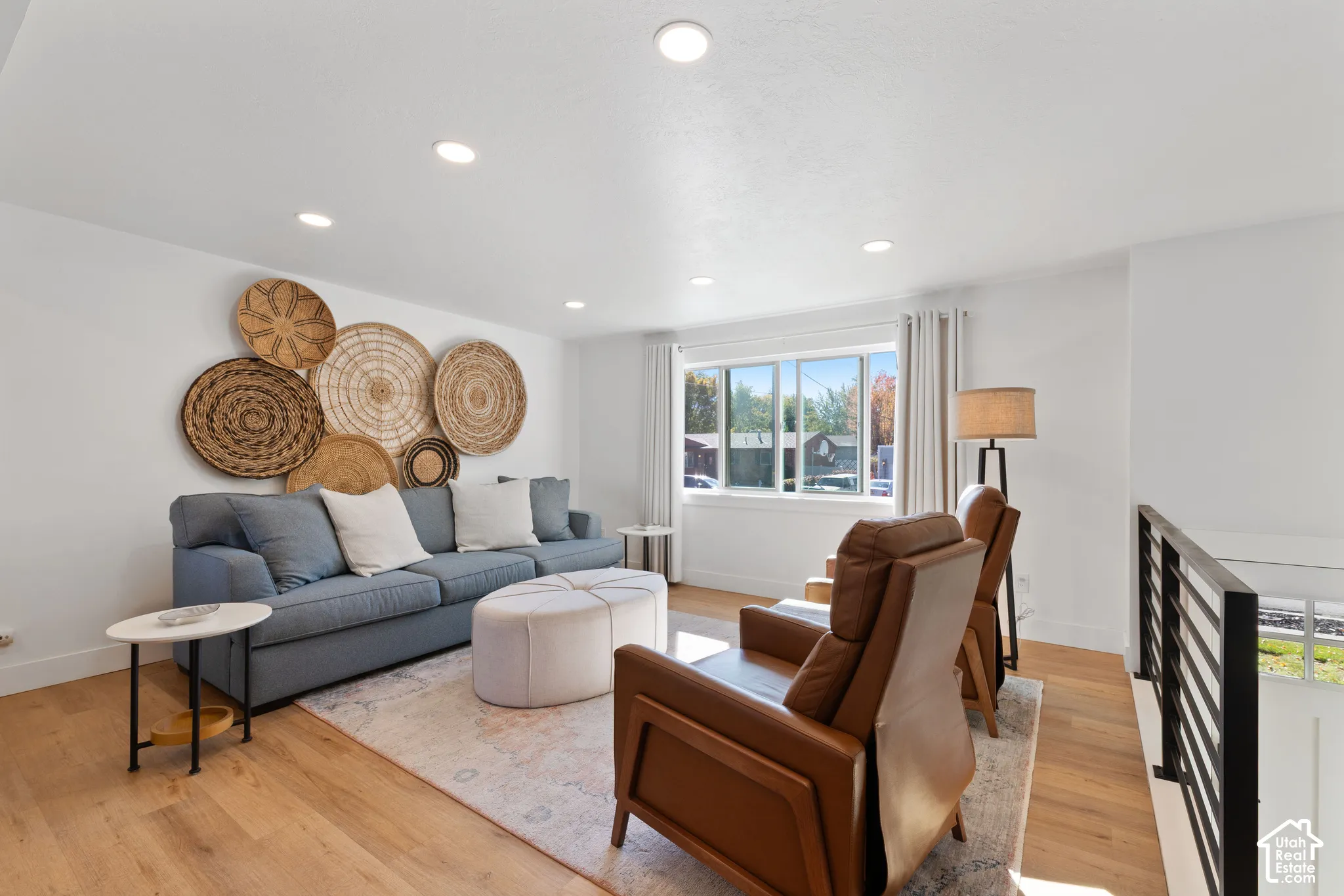 Living space featuring wood-finish flooring, recessed lighting, and metal stair railing