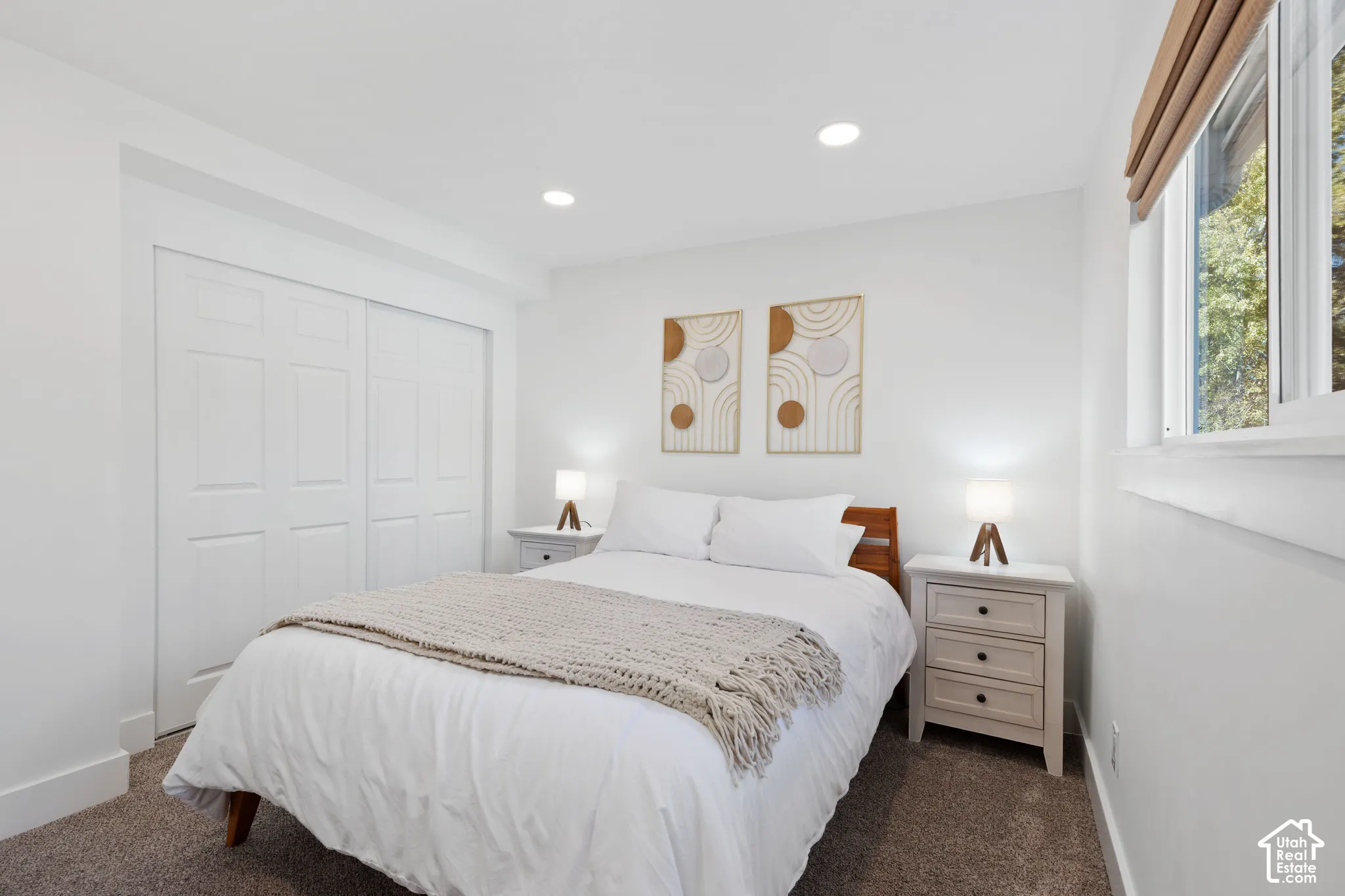 Bedroom featuring neutral wall-to-wall carpeting, recessed ceiling lighting, sliding-panel closet doors, and a double-pane window