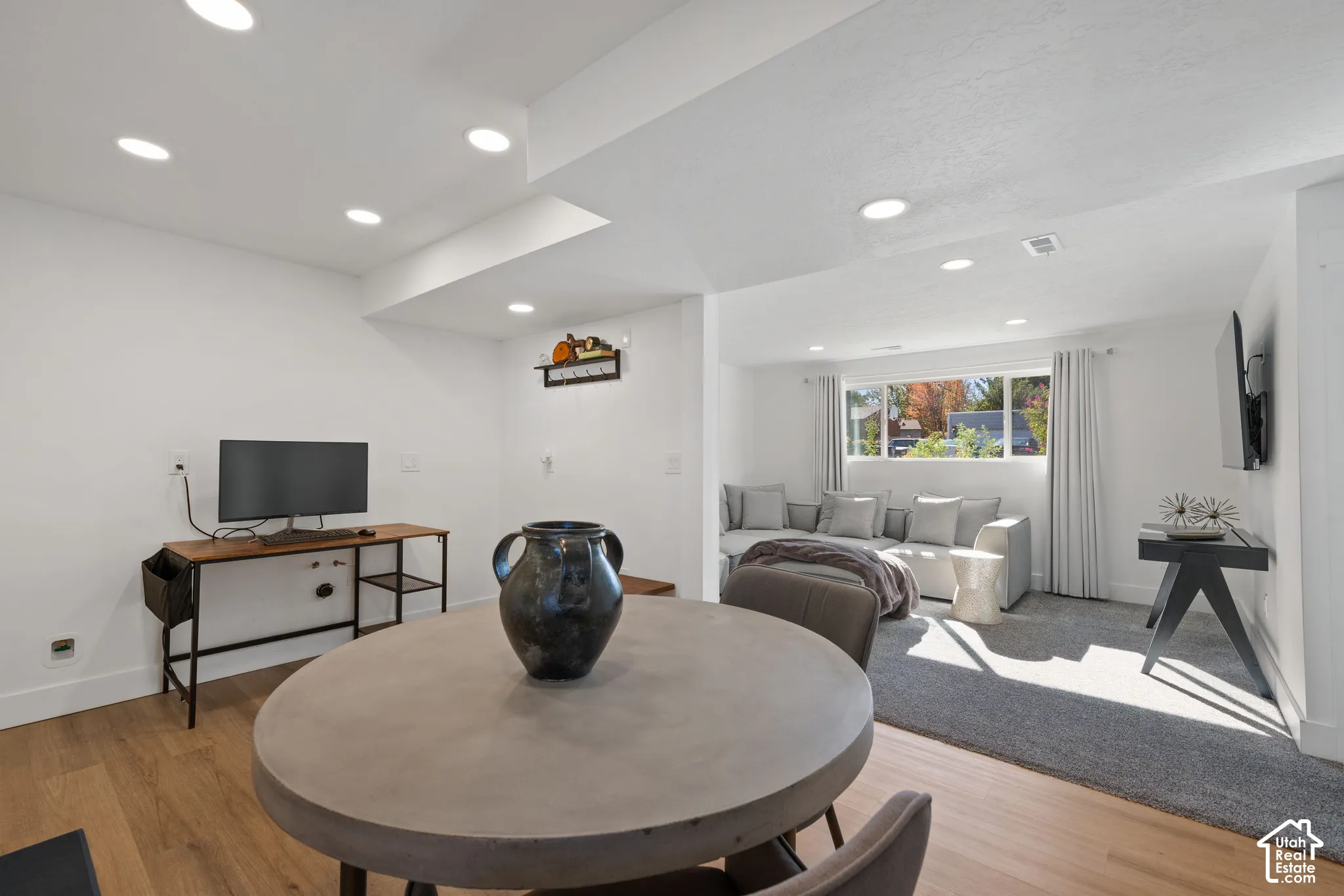 Open-concept interior featuring recessed lighting, wood-finish flooring, wall-to-wall carpeting, and a rectangular window
