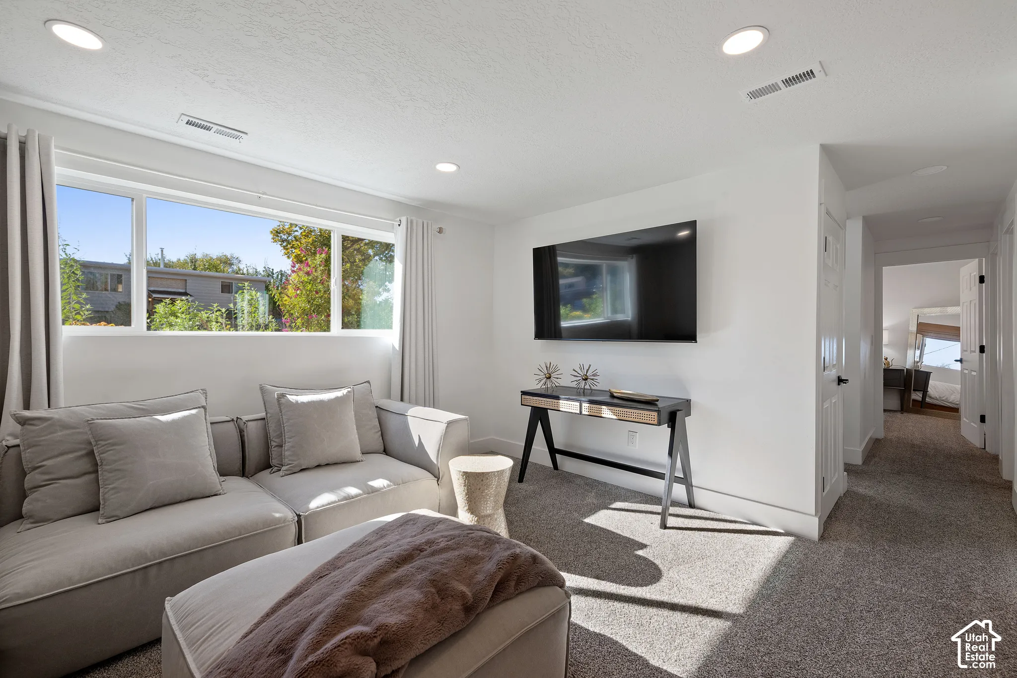 Living area featuring large windows, recessed lighting, and wall-to-wall carpeting