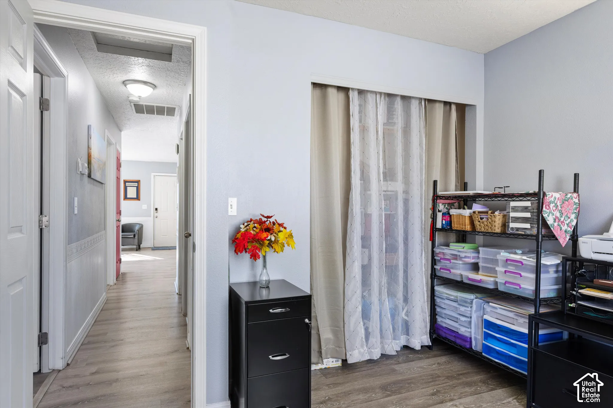 Interior space featuring light-toned wood-finish flooring, neutral wall paint, a built-in recessed closet area, and flush-mount ceiling lighting