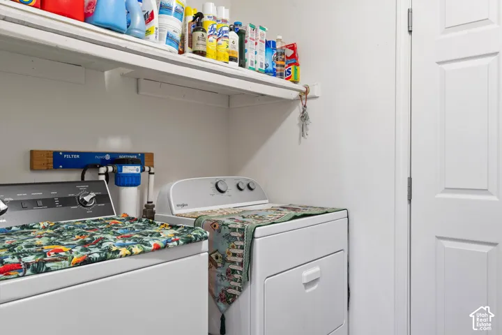 Laundry area featuring white cabinetry shelving, a plumbed water softener system, and a solid-core interior door