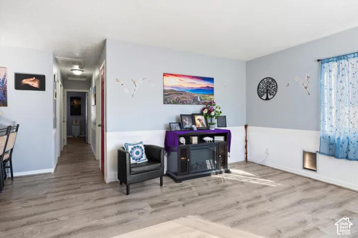 Wood-finish flooring, white wainscoting, and neutral wall paint