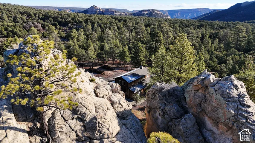 Residential property featuring expansive forested surroundings, prominent natural rock formations, and mountain topography