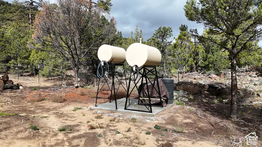 Dual elevated storage tanks mounted on a concrete pad, secured by metal framing