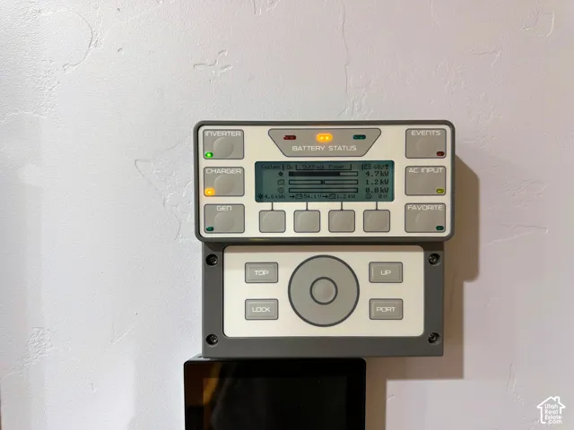 Wall-mounted power management system featuring a digital battery status display, integrated inverter and charger controls, and a multi-button tactile interface