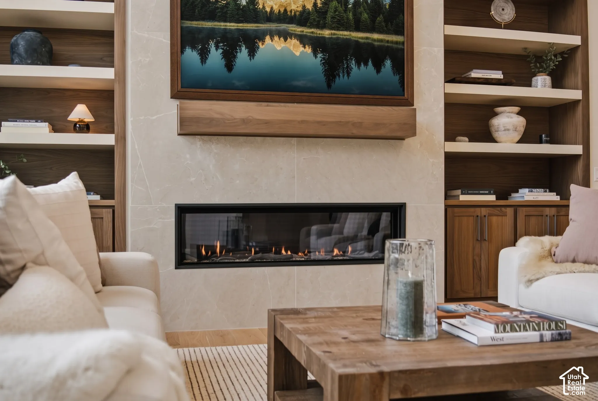 "Montego" 63" Linear gas fireplace featuring large-format tile surround, integrated walnut mantel, and flanking recessed, built-in walnut shelving