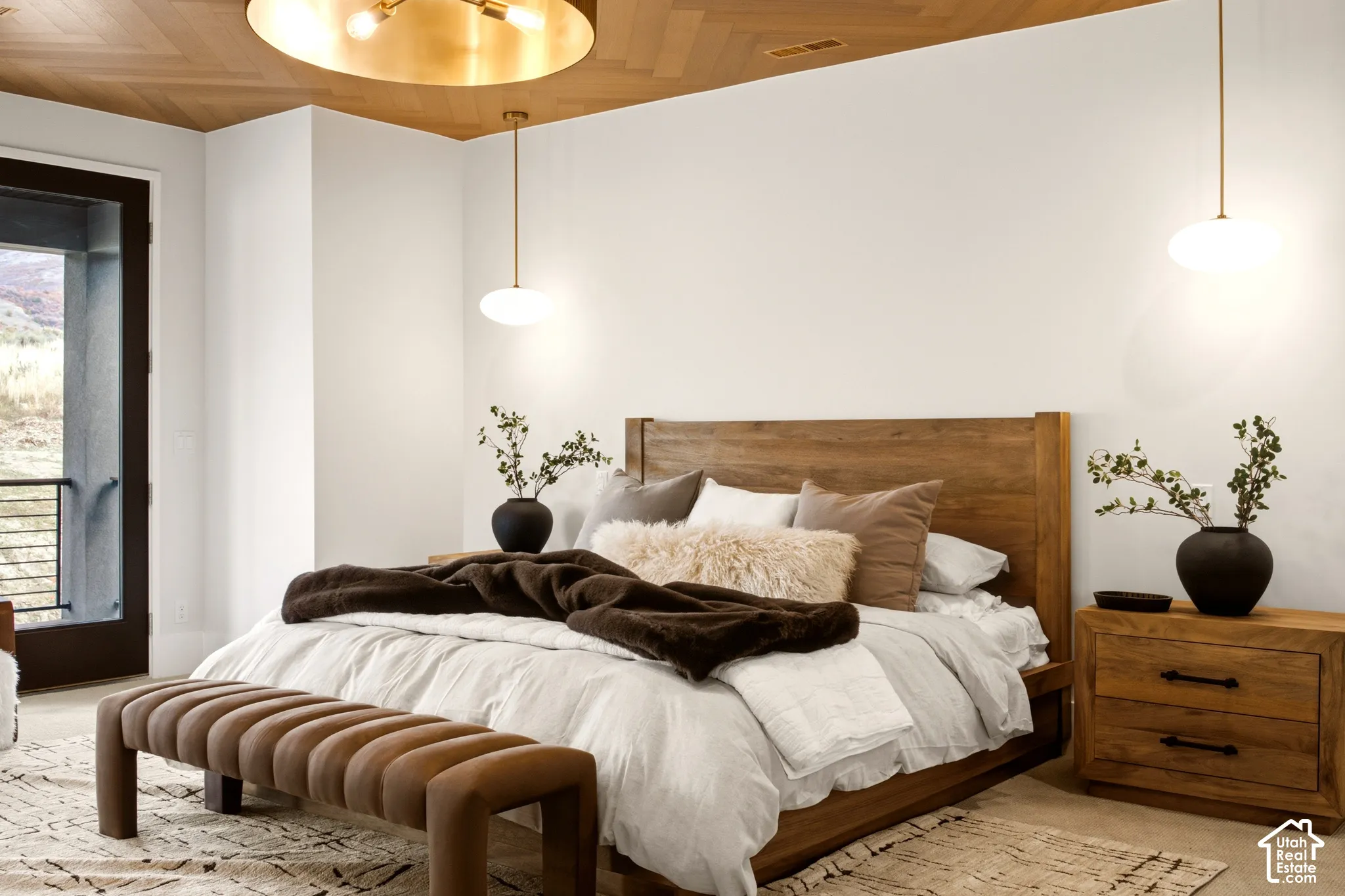 Primary Bedroom with Herringbone-Engineered hardwood ceiling featuring statement lighting and dual brass pendant fixtures.