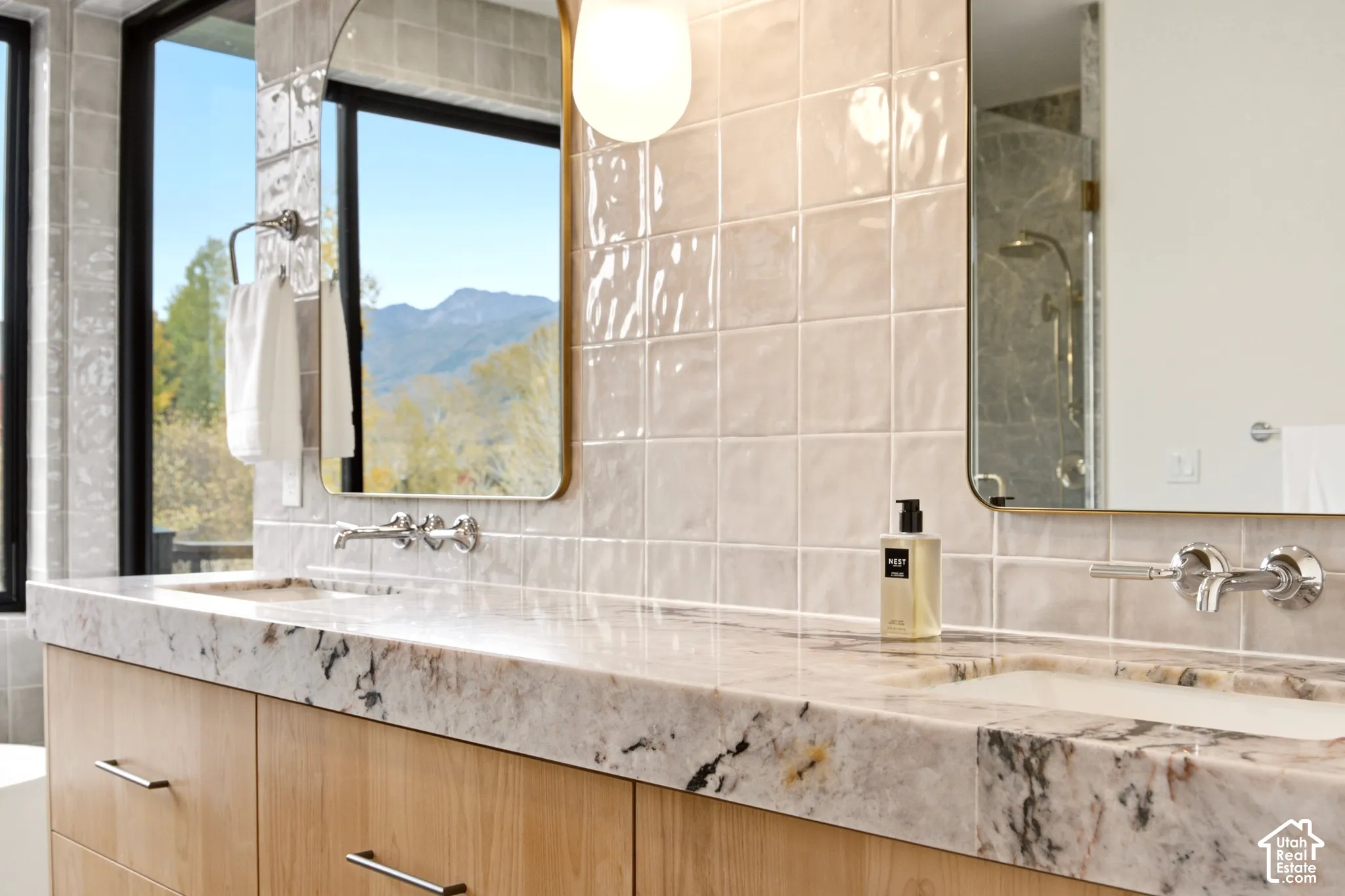 Primary Bathroom with Dual-sink floating vanity and 4" Tempest Crystal Quartzite countertop, wall-mounted Kohler "Tone" polished chrome faucets, Brass arched vanity mirrors, and gloss-finish Tile bar wall tiles