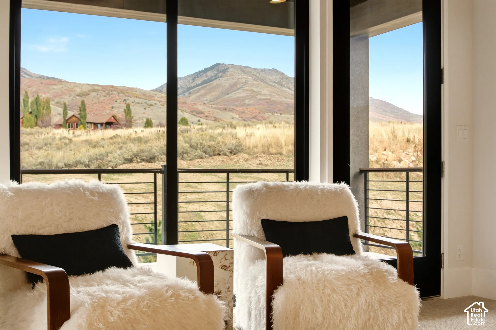 Primary bedroom sitting area with a mountain backdrop overlooked by the private balcony
