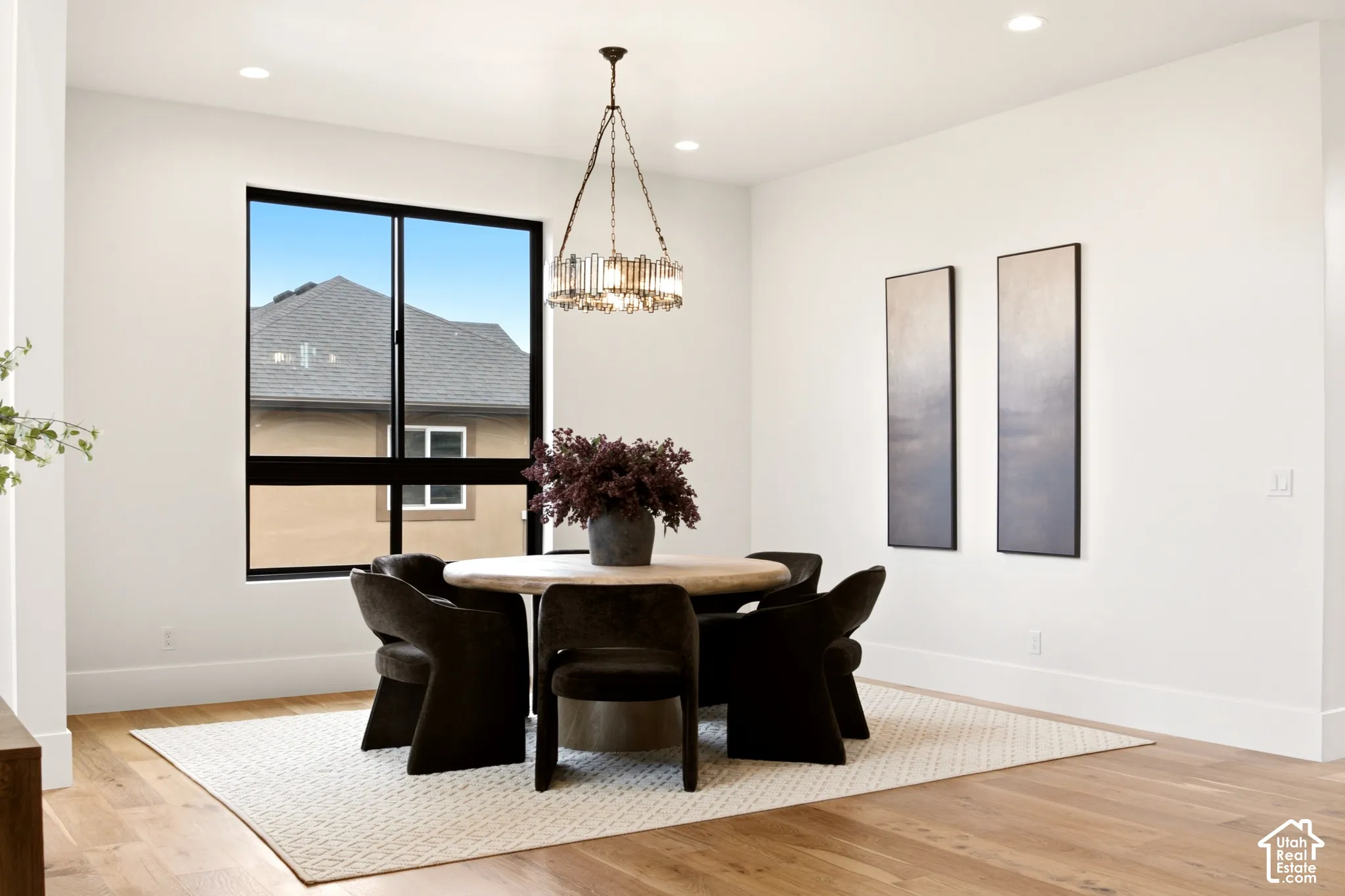 Dining space featuring Engineered Hardwood flooring, recessed lighting, a statement Arhaus metal chandelier, and a large black-framed window