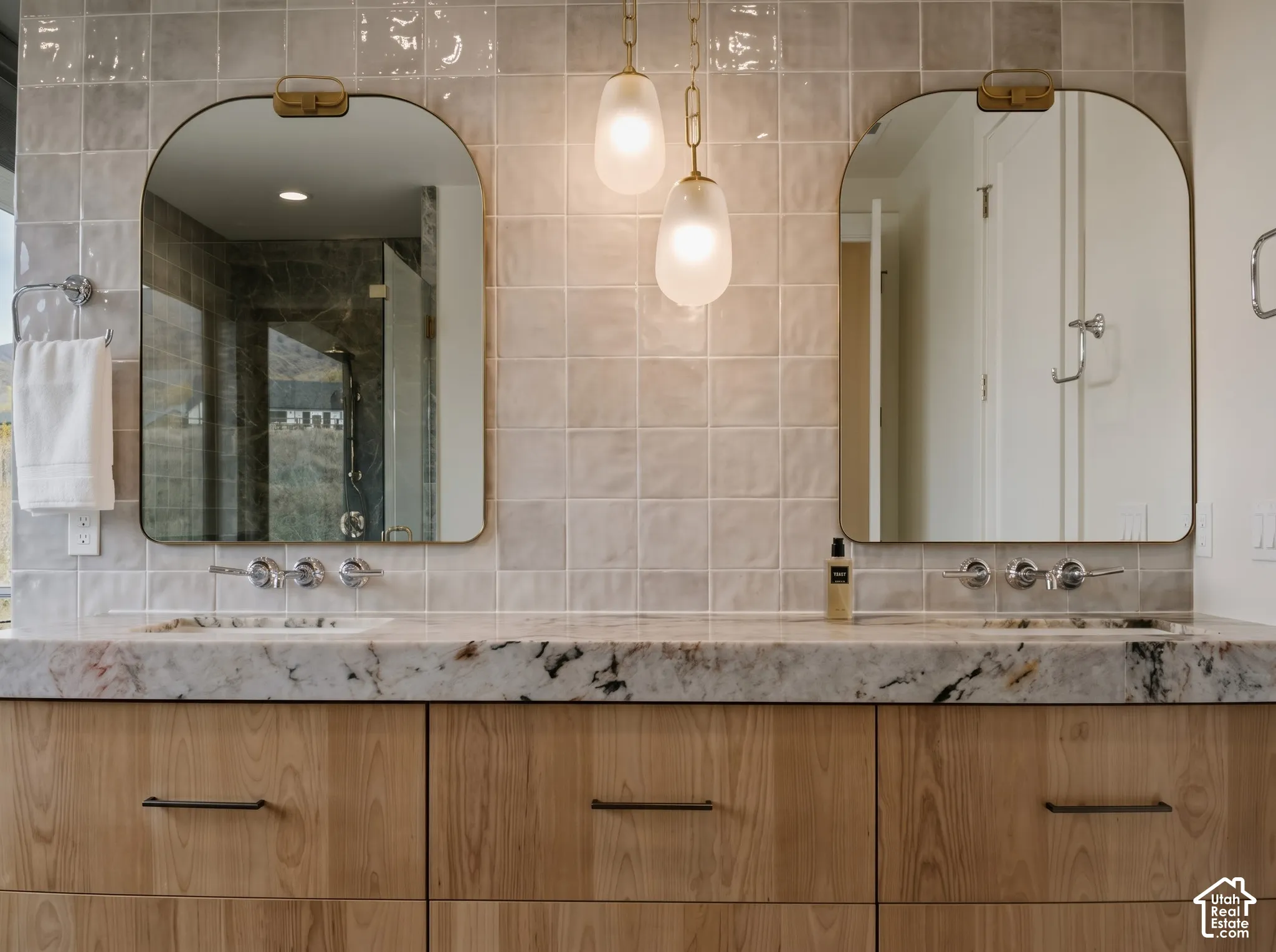 Primary Bathroom featuring 4" Tempest Crystal Quartzite counters, brass arched mirrors, Edward Martin Pendants, Kohler Tone wall-mounted faucets, Floating double vanity, and textured tile wall backsplash