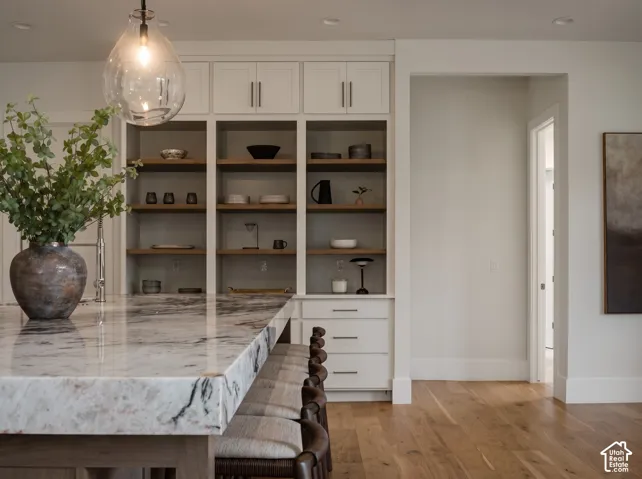 4" Tempest Crystal Quartzite countertop custom floor-to-ceiling built-in cabinetry, walnut shelving, statement glass pendant lighting, and engineered hardwood flooring