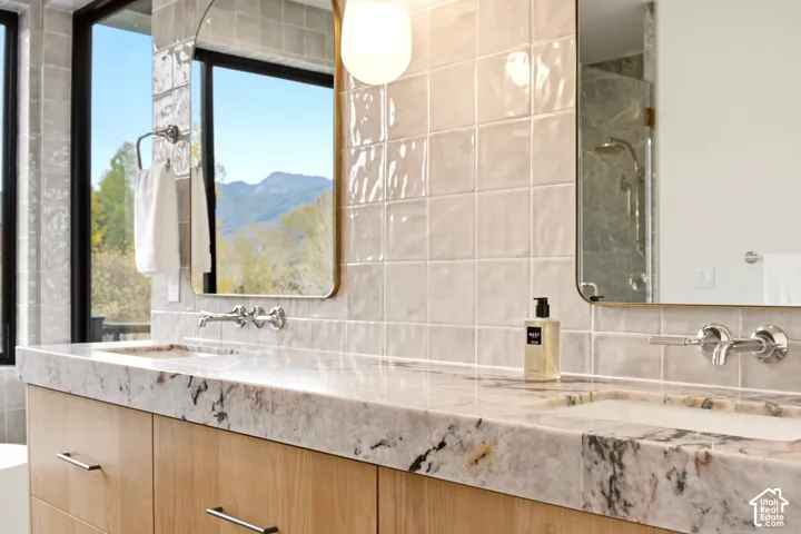 Primary Bathroom with Dual-sink floating vanity and 4" Tempest Crystal Quartzite countertop, wall-mounted Kohler "Tone" polished chrome faucets, Brass arched vanity mirrors, and gloss-finish Tile bar wall tiles