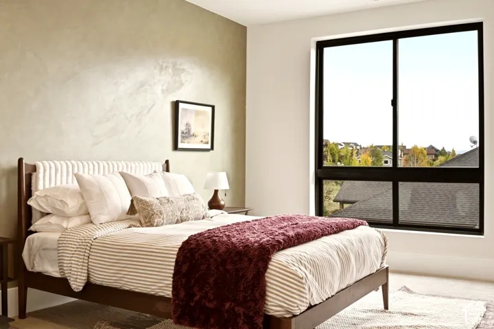 Second story bedroom with Portola Paint Roman Clay accent wall, large black-framed windows, and carpeted flooring
