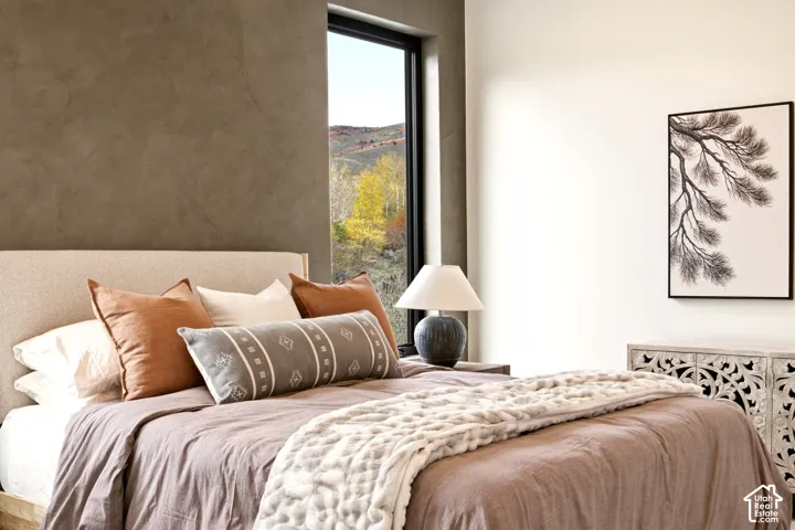 2nd story bedroom with Portola Roman Clay accent wall, large black casement windows, with mountain views
