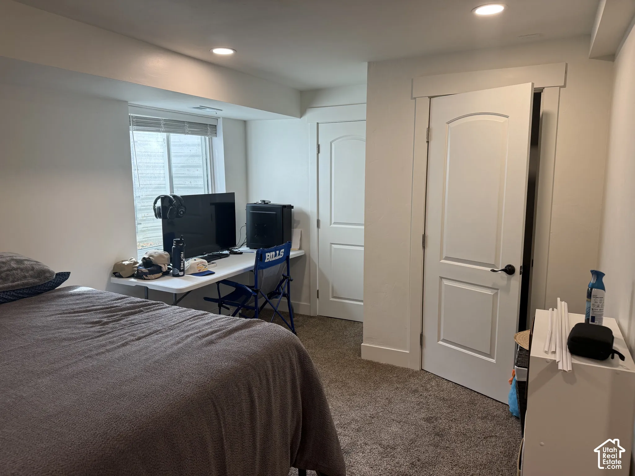 Interior room featuring carpeted flooring, recessed lighting, white panel doors, and a window with a horizontal blind