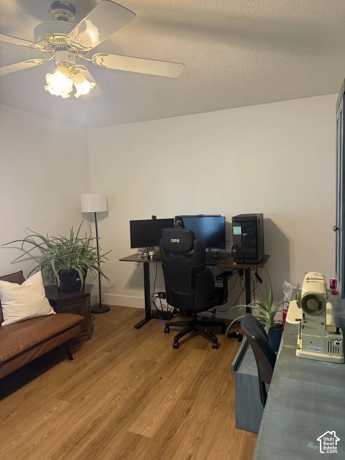 Wood-finish flooring and a ceiling-mounted light fixture with a fan