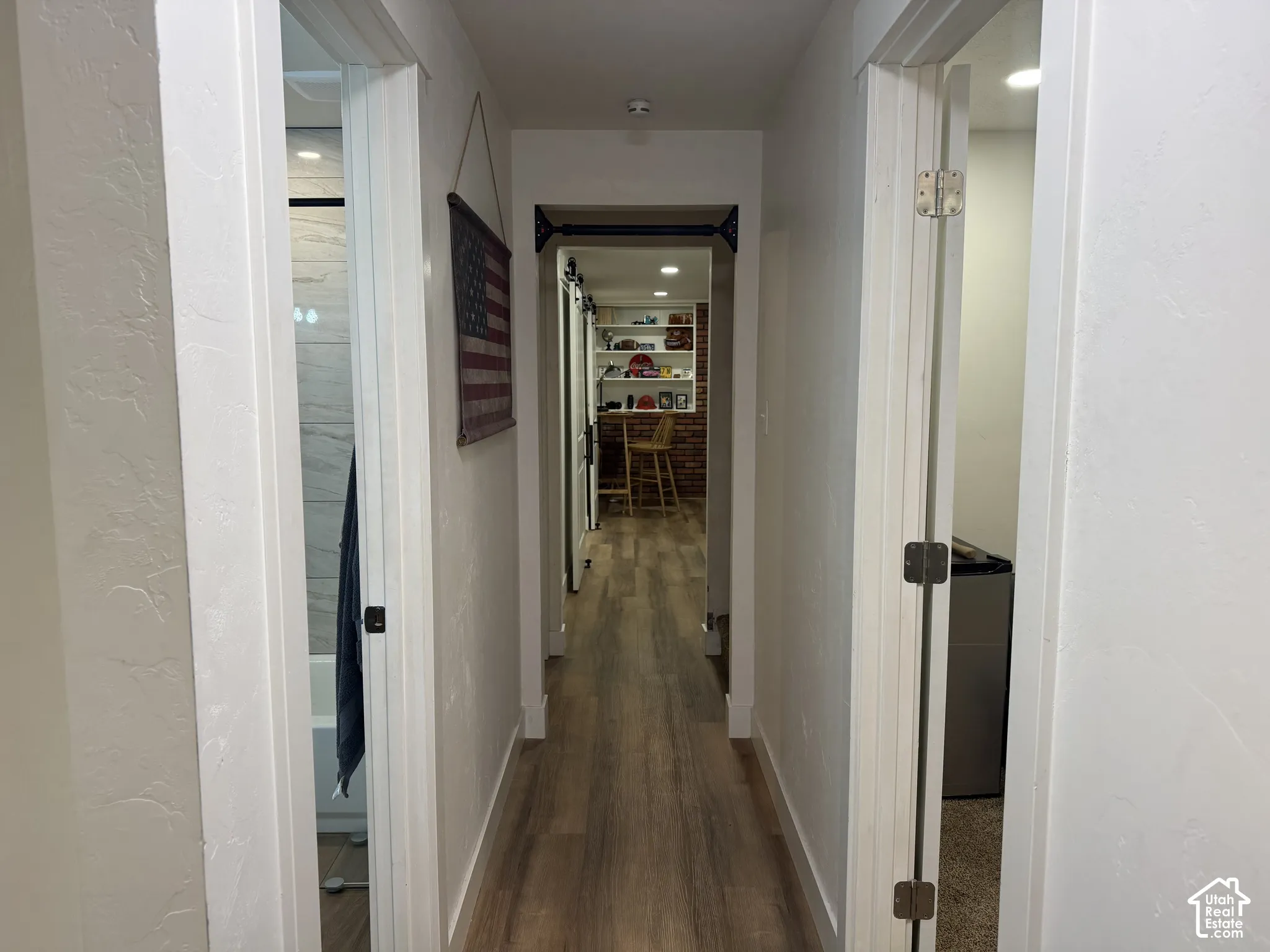 Hallway featuring wood-finish flooring, recessed lighting, and built-in shelving