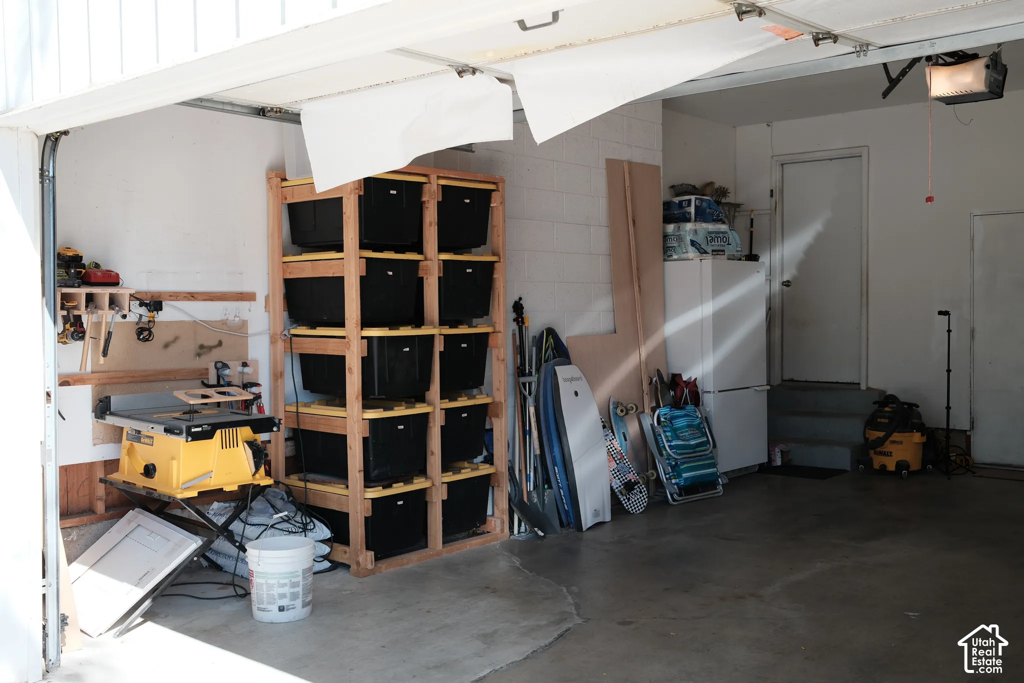 Garage interior featuring concrete flooring, painted block walls, and an integrated ceiling-mounted automatic door opener
