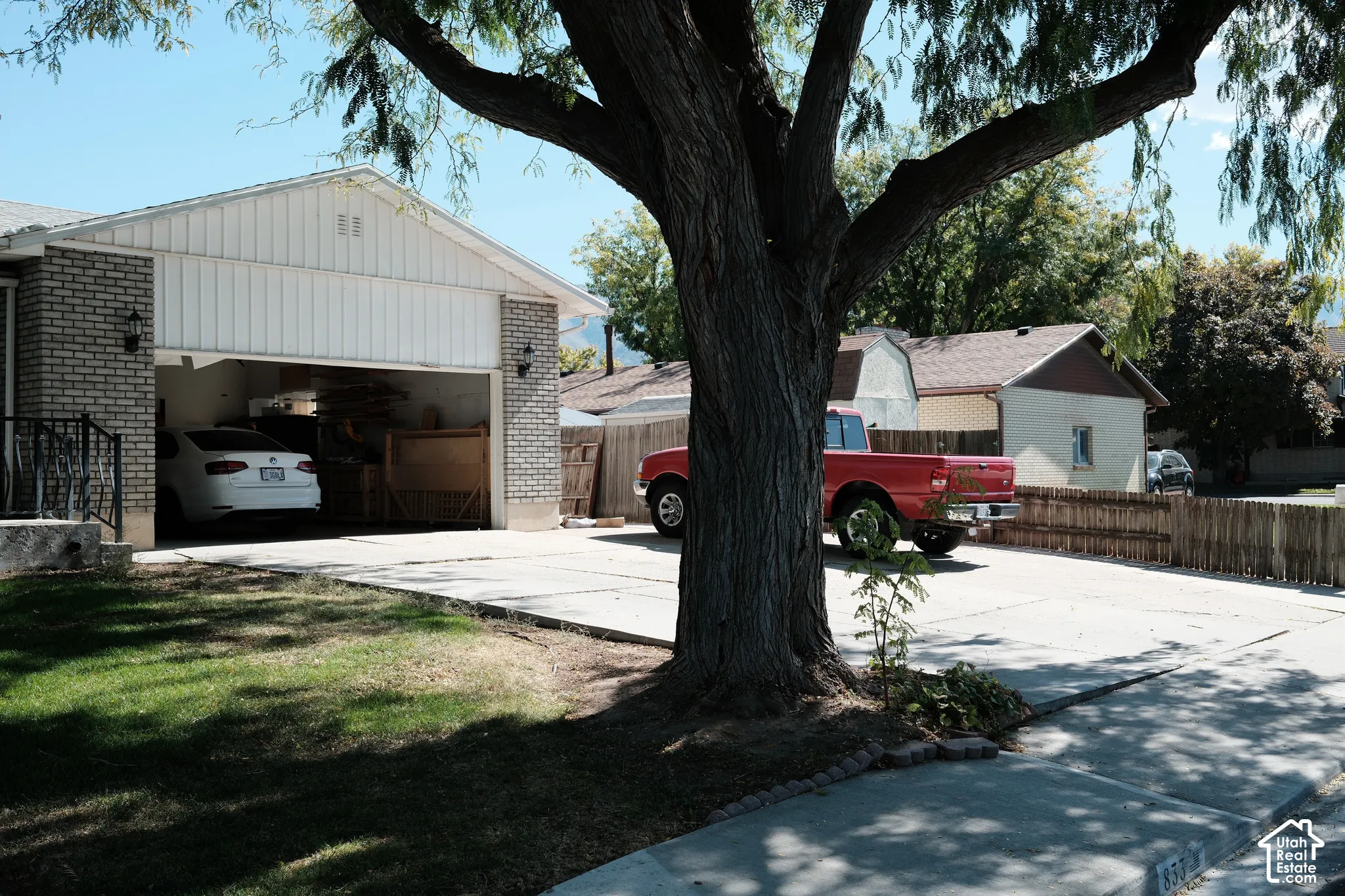 Exterior featuring brick and vertical siding, attached garage, and concrete driveway