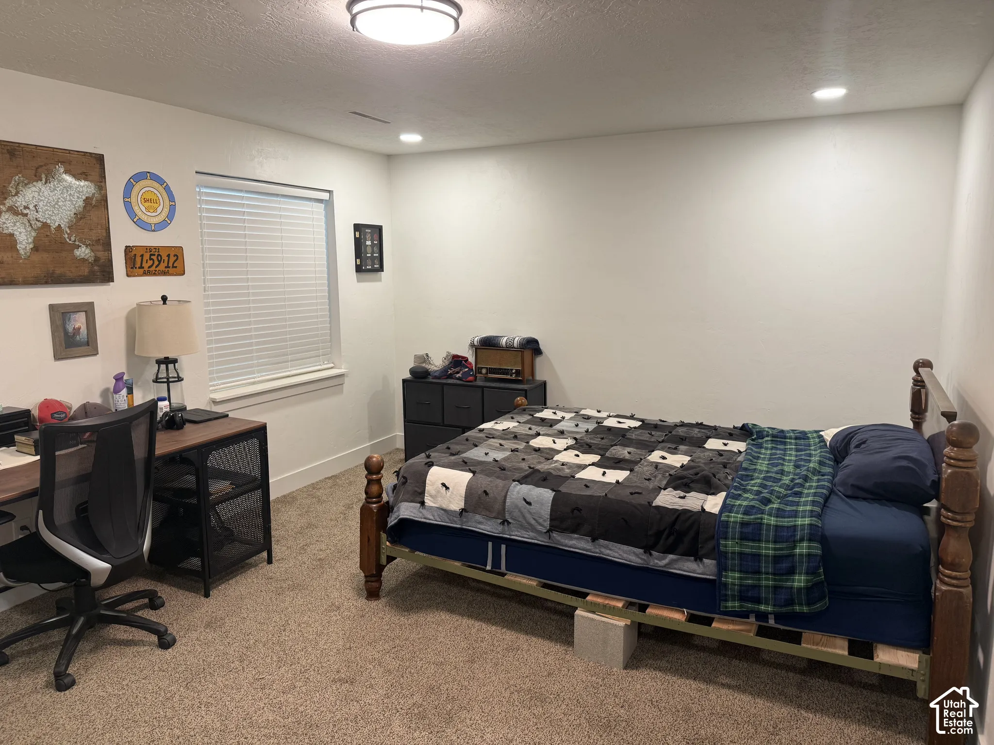 Neutral-toned carpeted flooring, flush-mount overhead lighting, recessed lighting, and a single-pane window with horizontal blinds