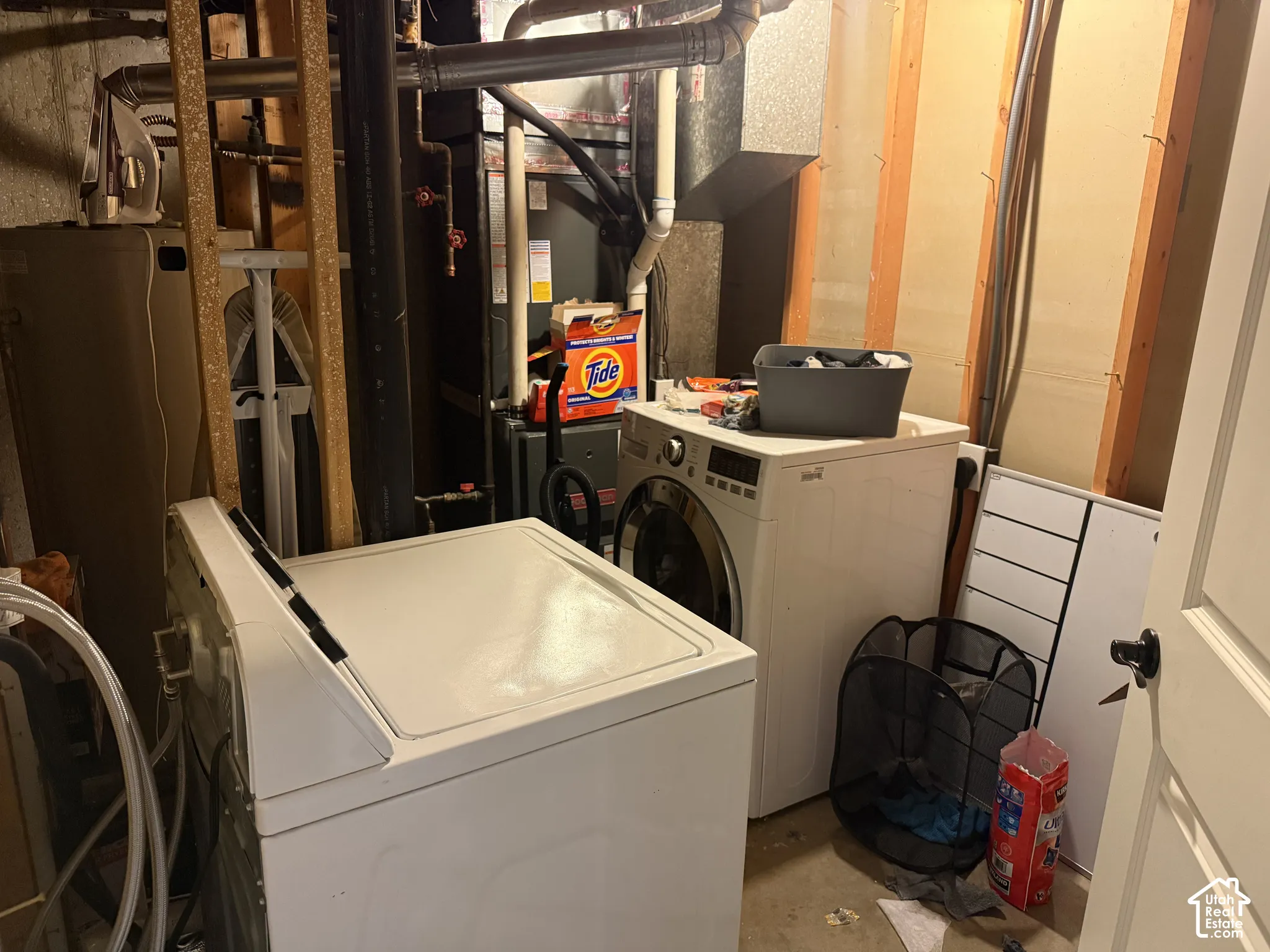 Utility area featuring an HVAC system, exposed wood wall studs, and plumbing infrastructure