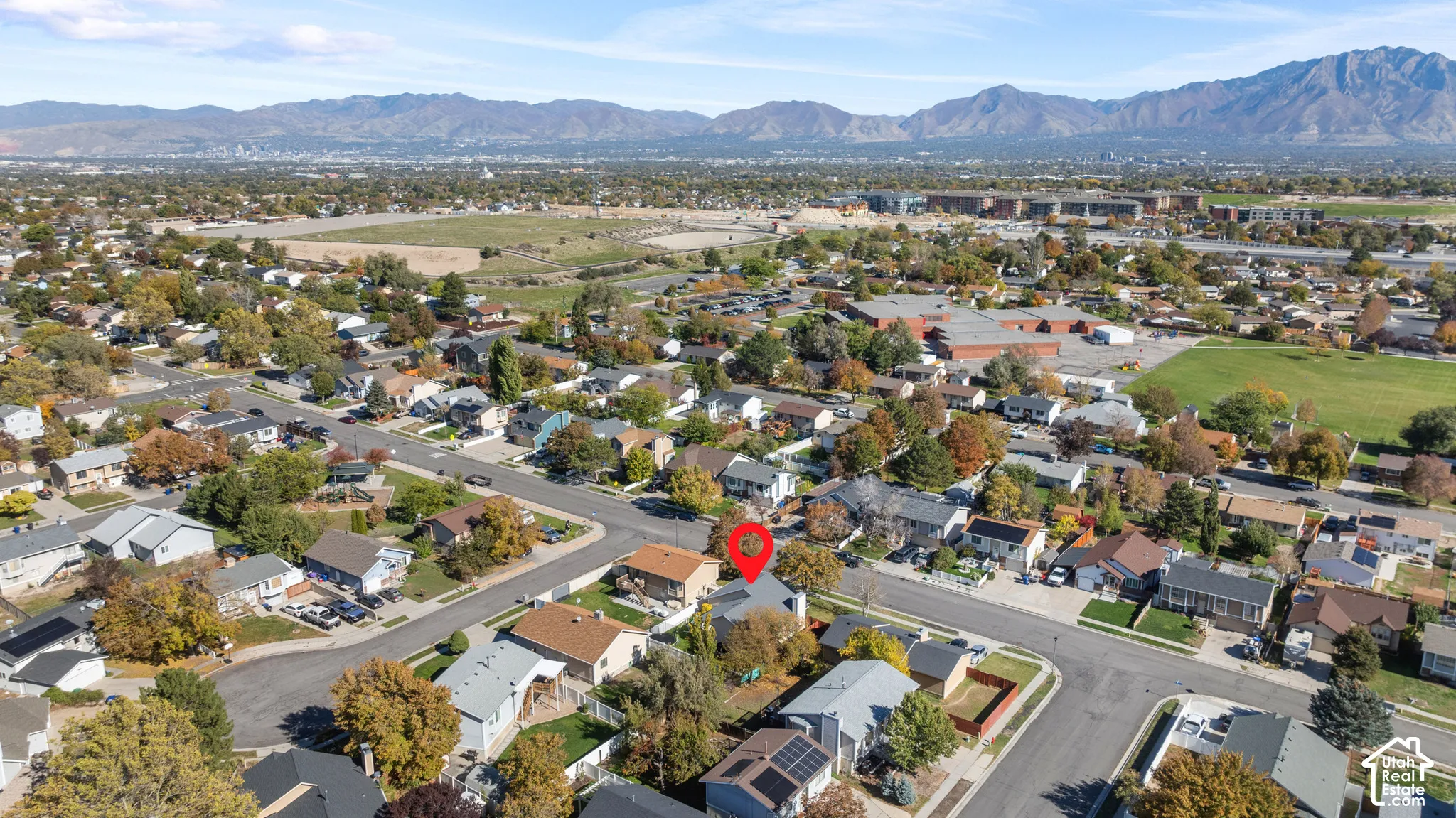 Aerial perspective of residential property featuring a pitched roofline, chimney, and mountain range backdrop