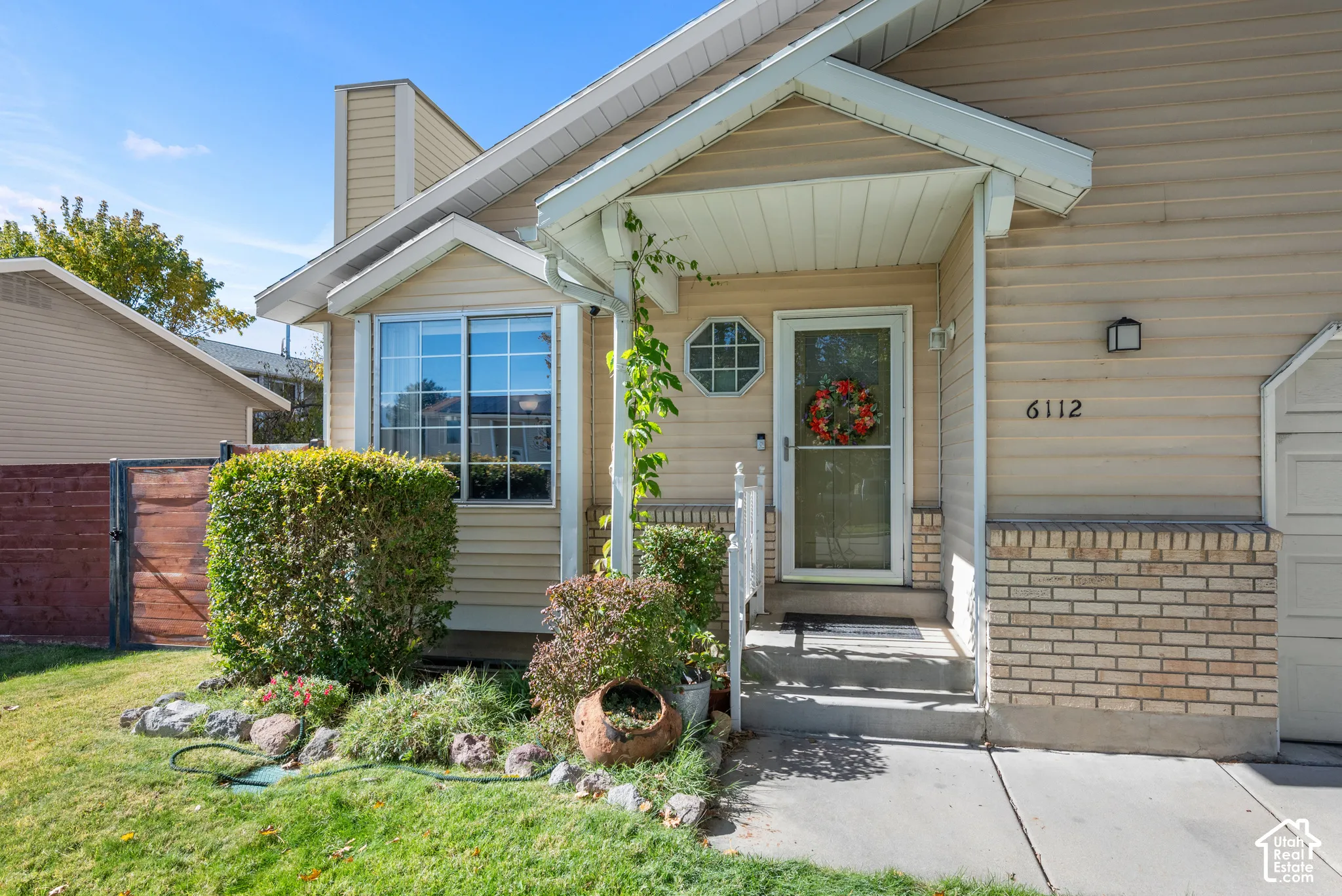 Exterior featuring horizontal lap siding, brick masonry detailing, an octagonal accent window, a covered entryway, and a concrete driveway