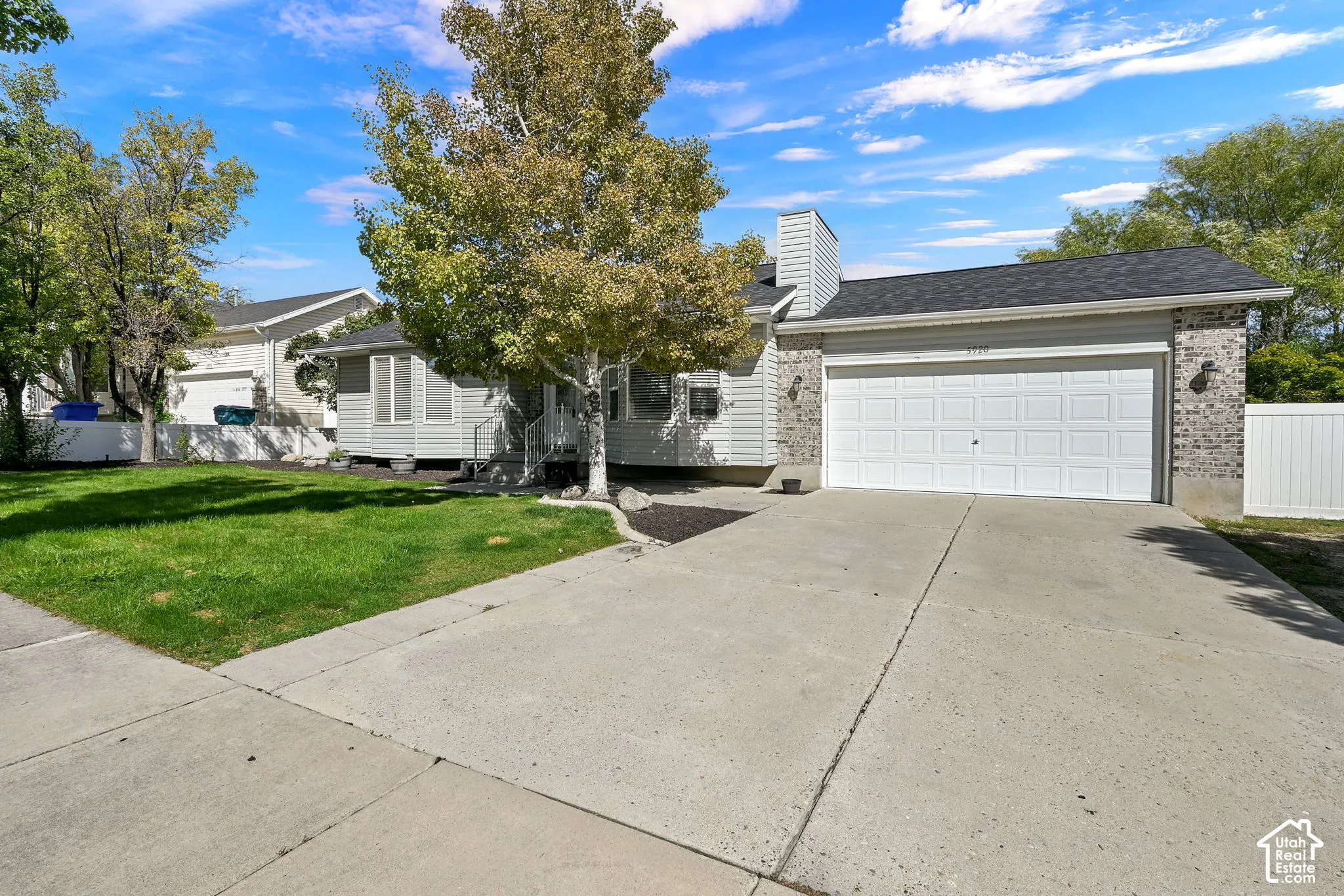 Single-story residence featuring a brick and horizontal siding exterior, attached two-car garage, concrete driveway, and front lawn landscaping