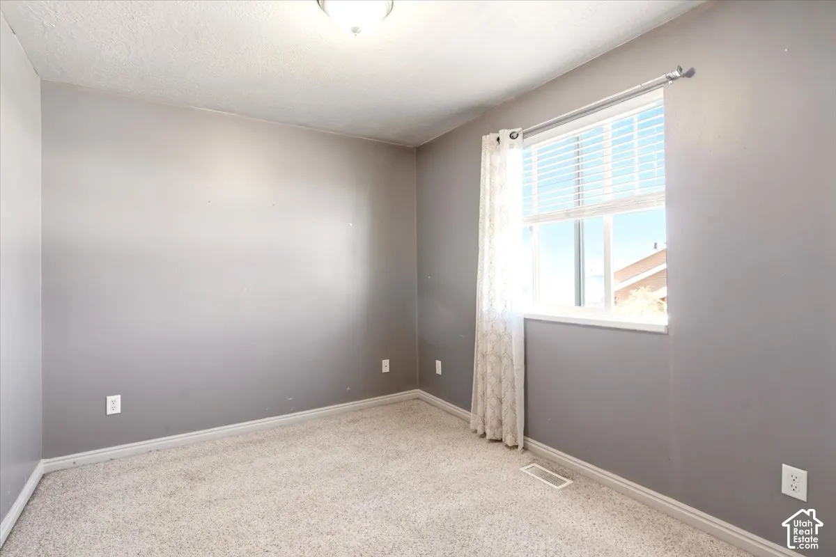 Room featuring neutral wall tones, wall-to-wall carpeting, and a window with blinds