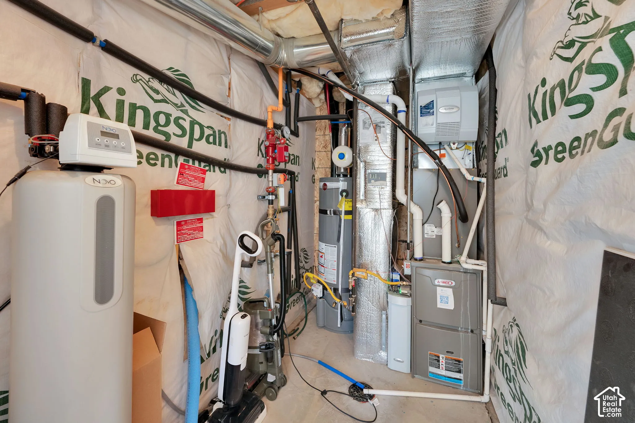 Utility mechanical area featuring a water softener, tank-style water heater, and forced-air furnace unit with insulated ductwork
