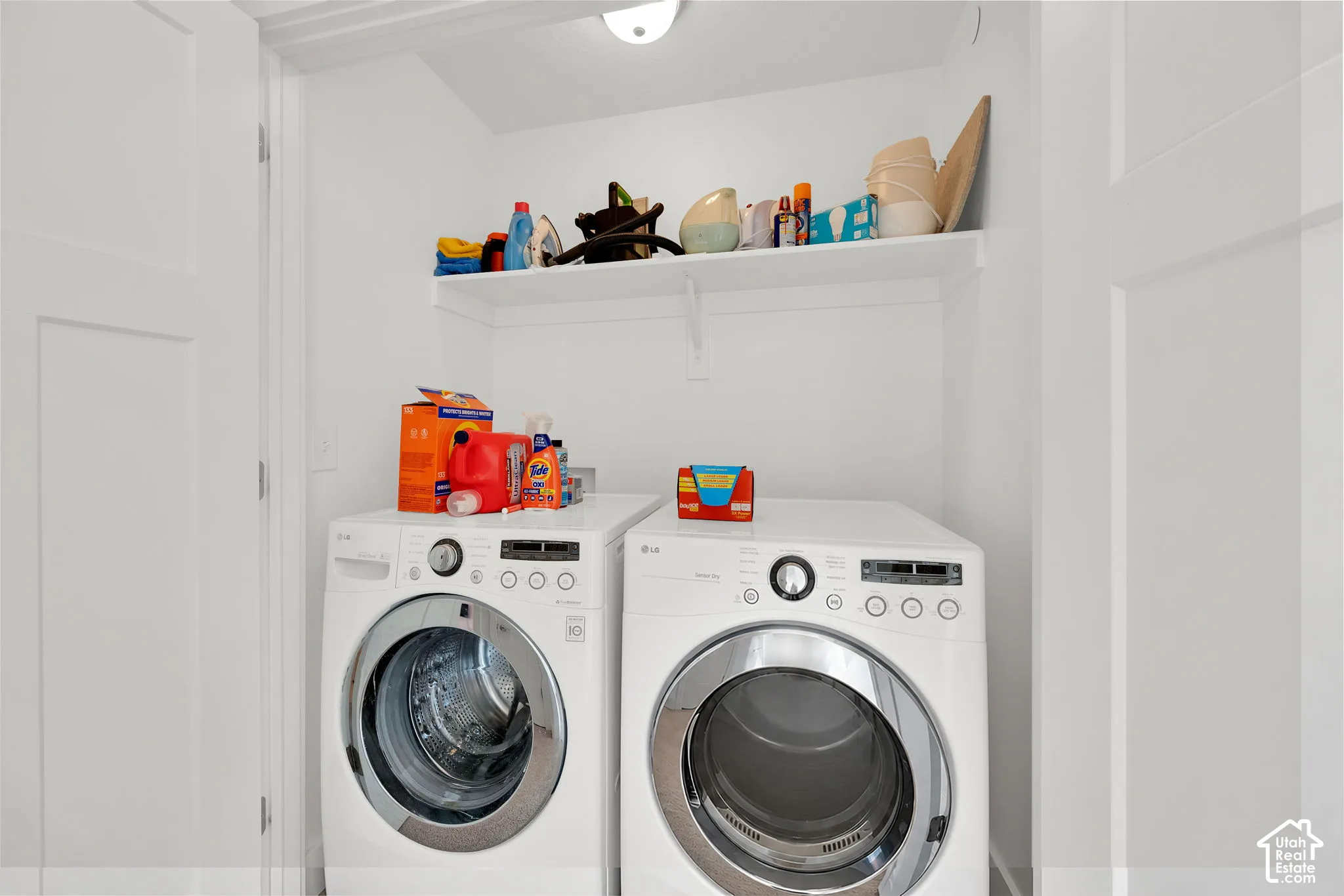 Dedicated laundry closet featuring a white-painted interior, an overhead fixed shelf, and a flush-mount light fixture