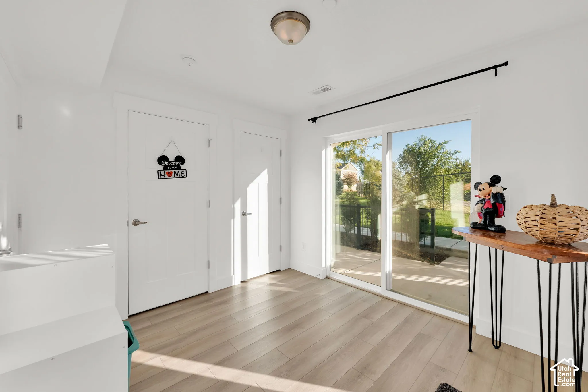 Interior space featuring wood-finish flooring, two-panel interior doors, and a glass sliding door providing exterior access