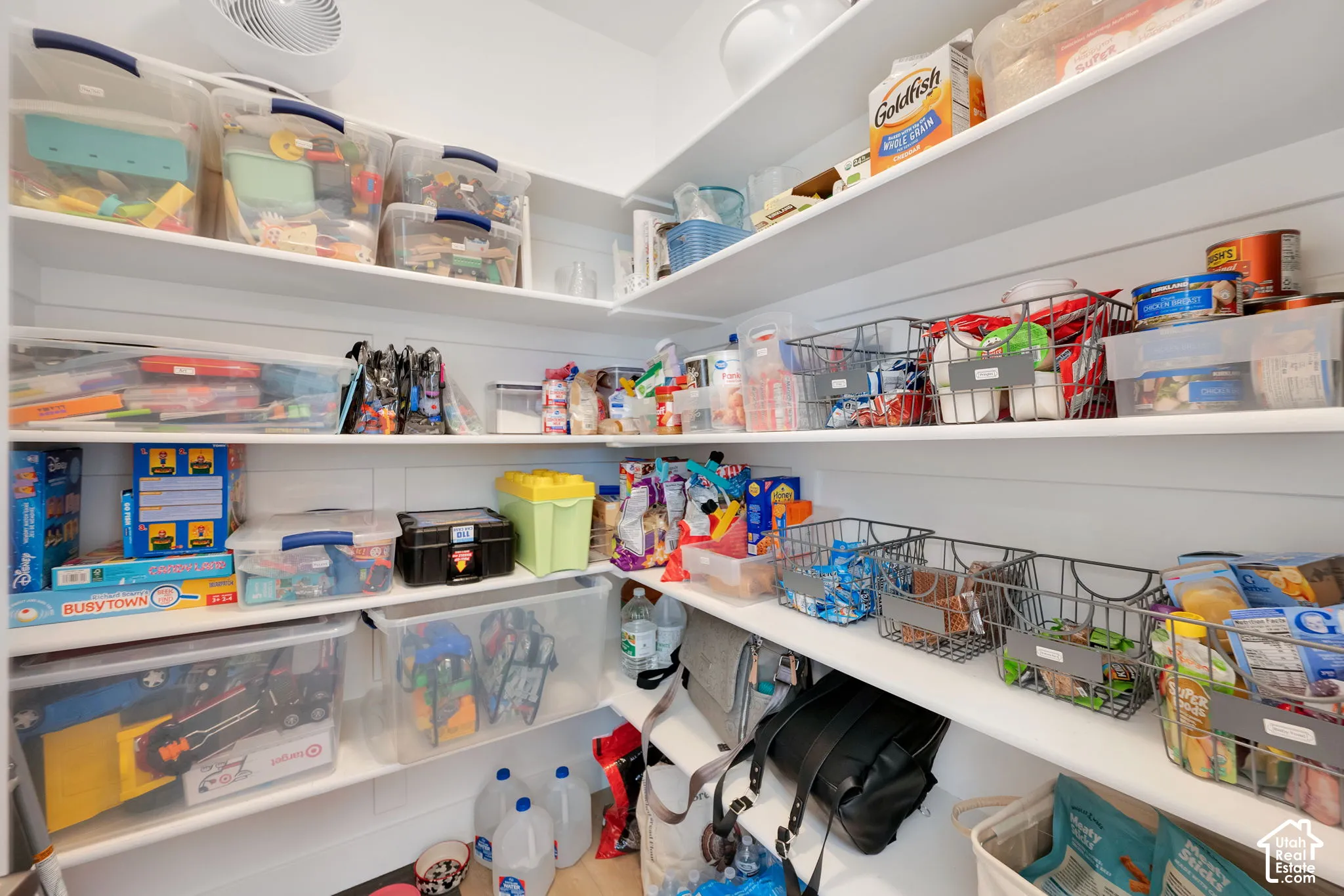 Walk-in pantry featuring white shiplap walls and multi-level built-in shelving