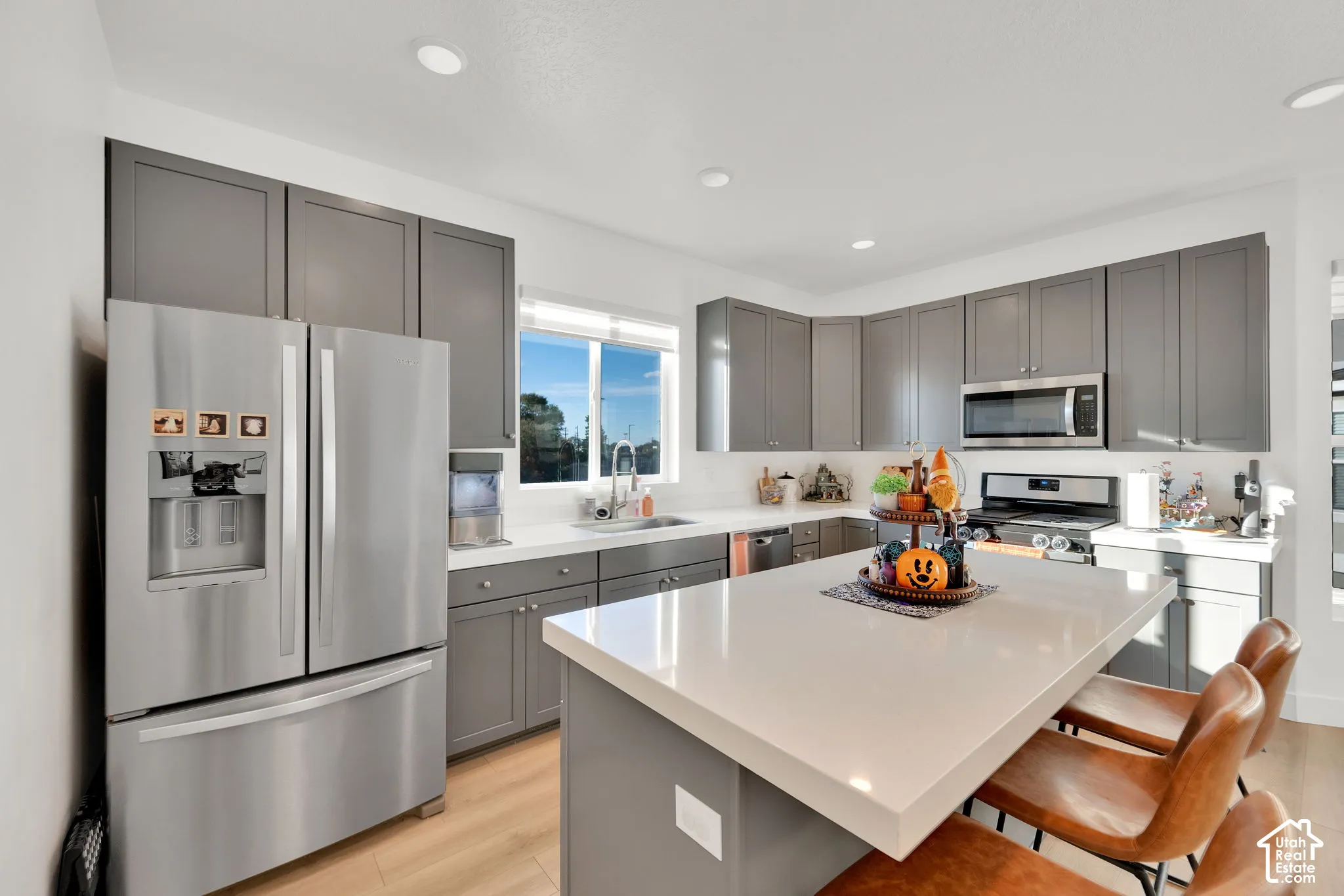 Kitchen featuring gray shaker-style cabinetry, a large central island with quartz countertop, stainless steel appliances, and recessed lighting