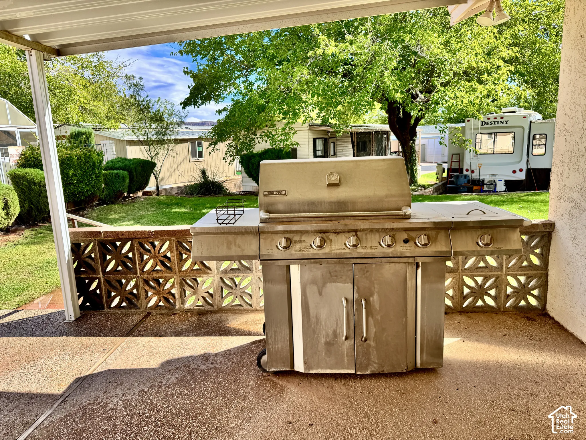 Covered patio featuring a concrete floor, decorative concrete block perimeter wall, and built-in stainless steel grill