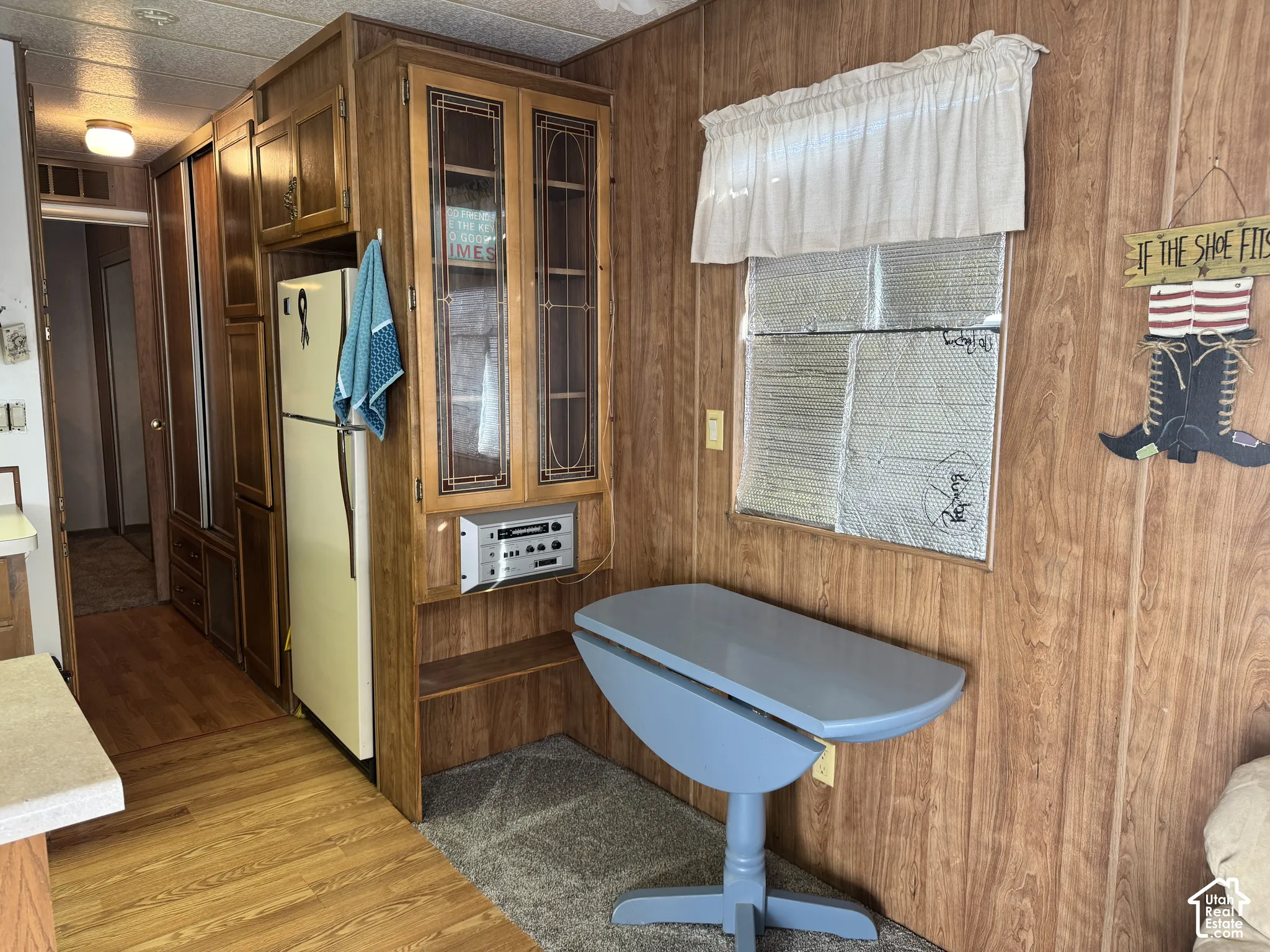 Wood-panelled interior featuring built-in cabinetry with decorative glass inserts and wood-finish flooring