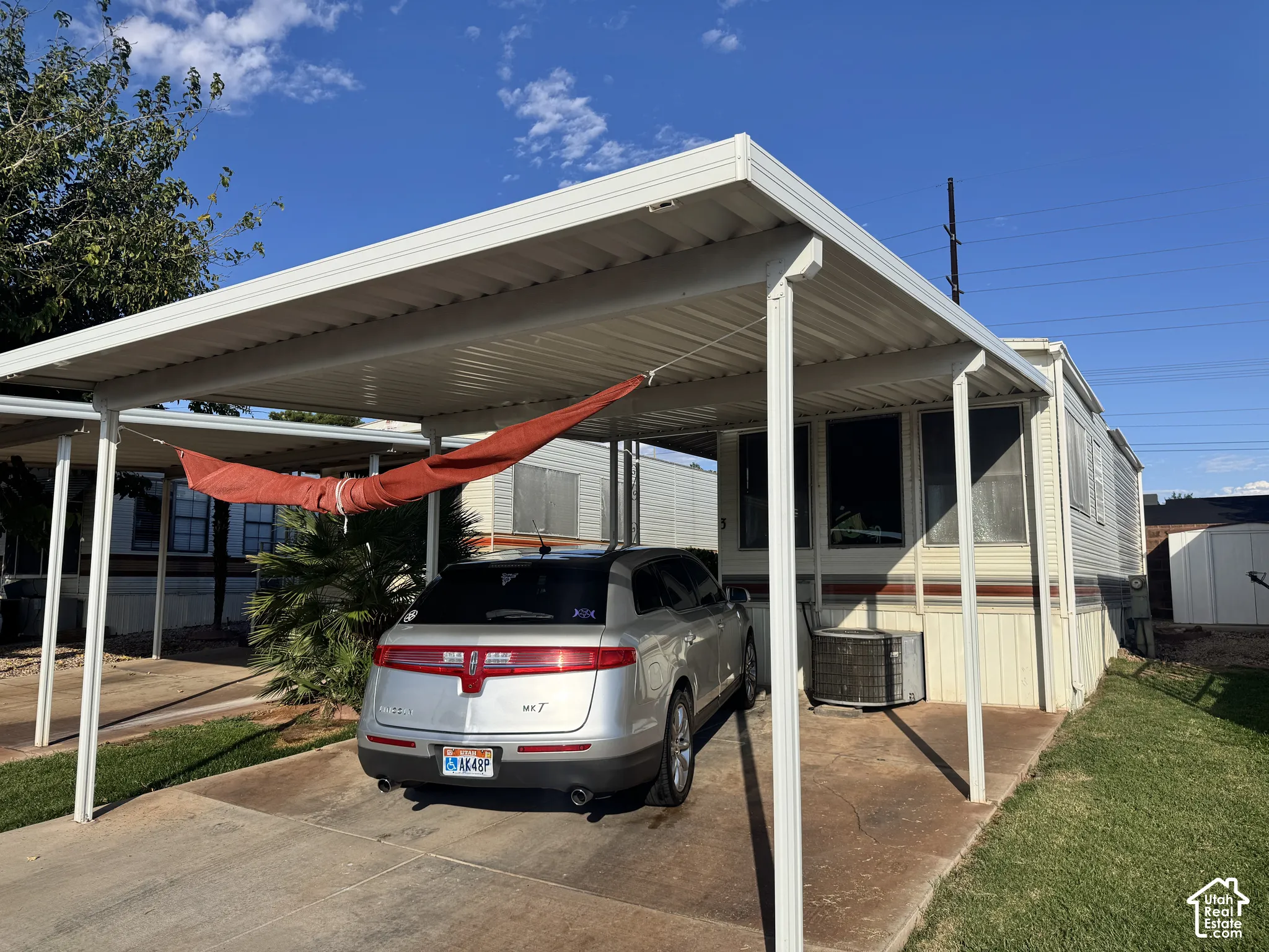 Covered carport featuring a metal roof, concrete slab, and integrated support columns