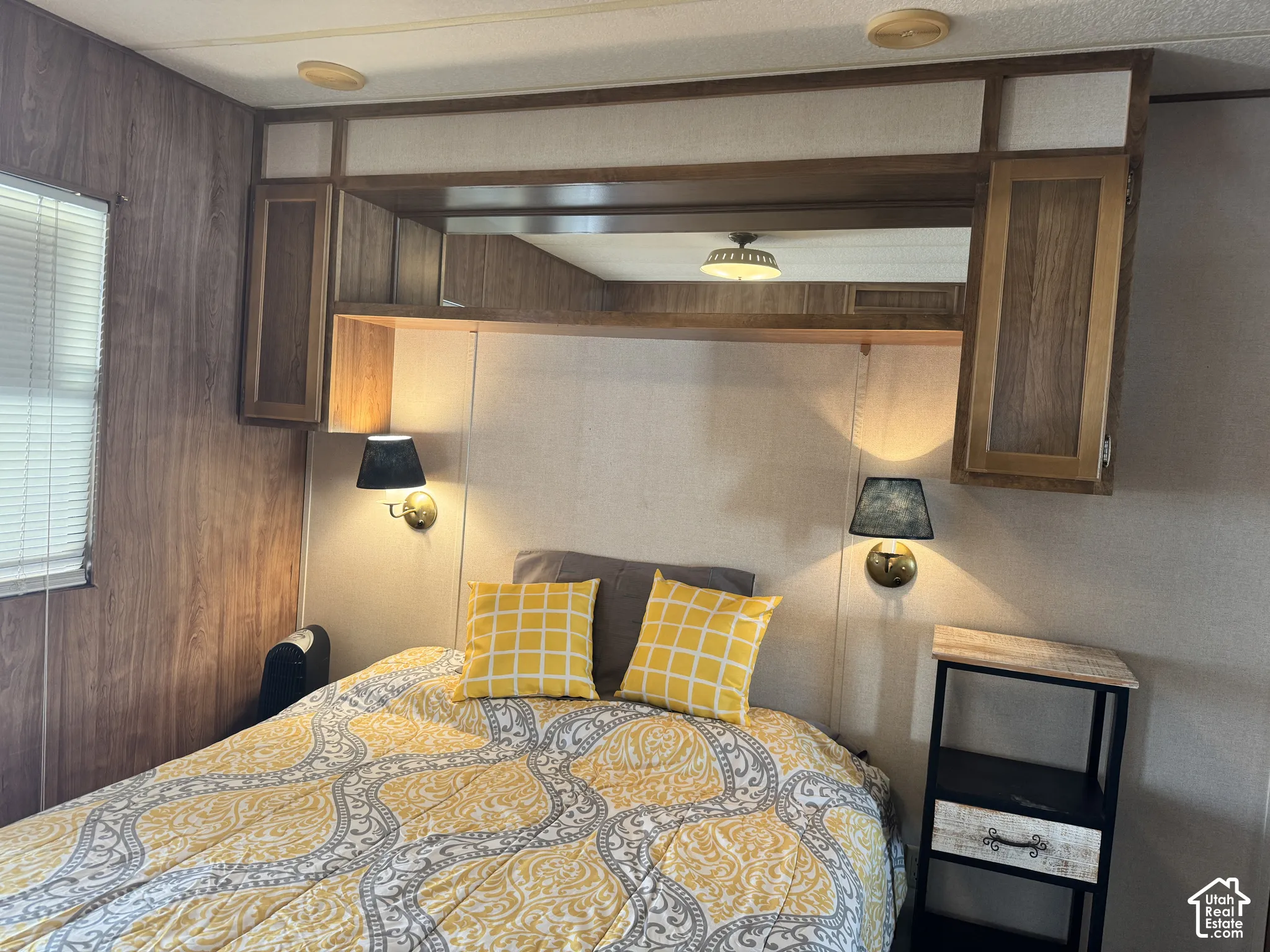 Built-in wall cabinetry featuring wood-frame doors, central mirrored panel, and integrated overhead lighting