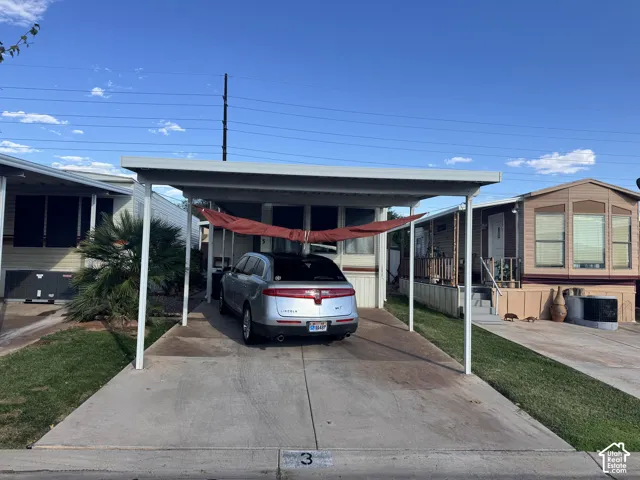 Covered metal carport with concrete driveway