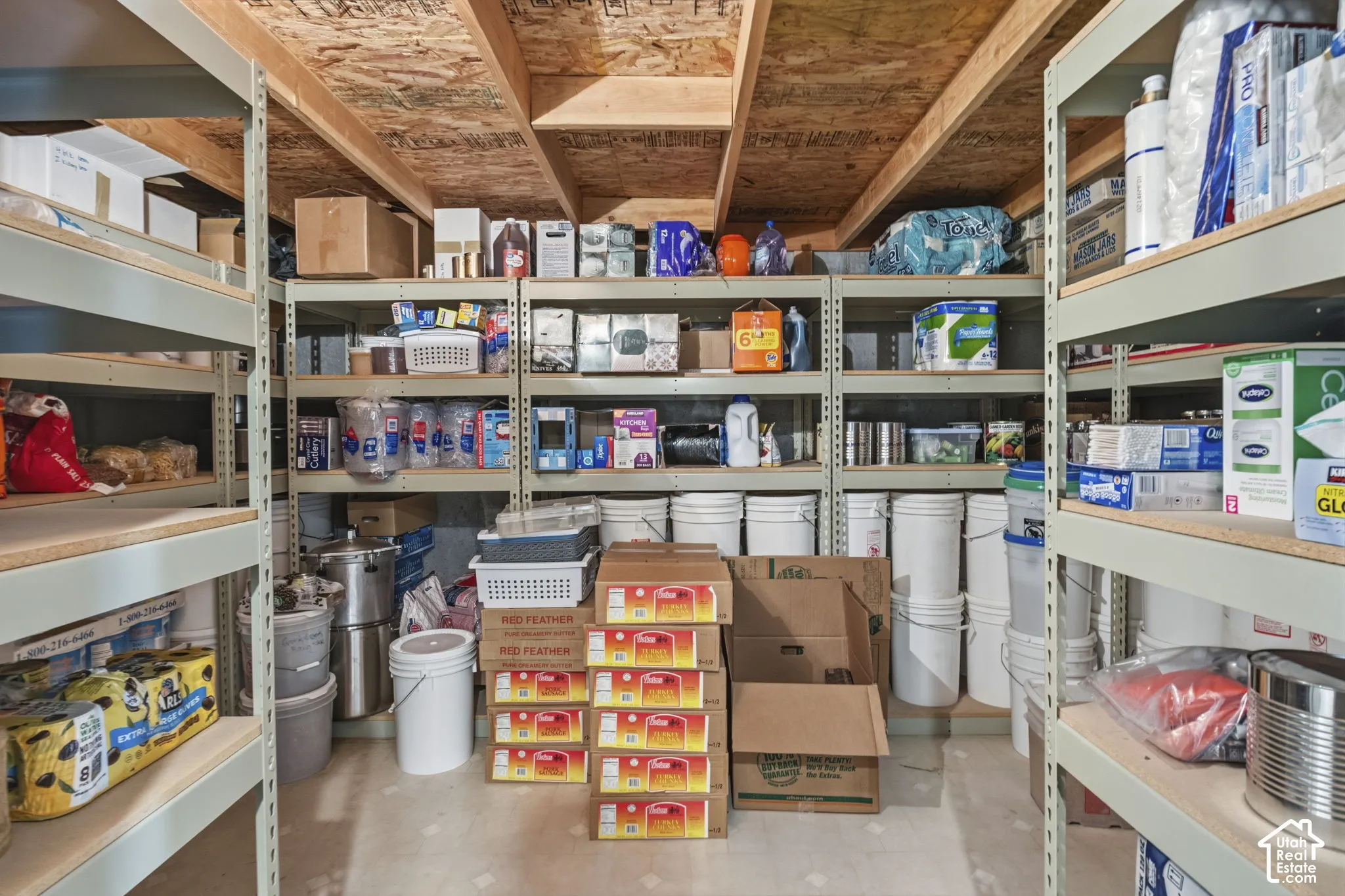 Dedicated storage space featuring floor-to-ceiling metal shelving units and exposed wood ceiling joists