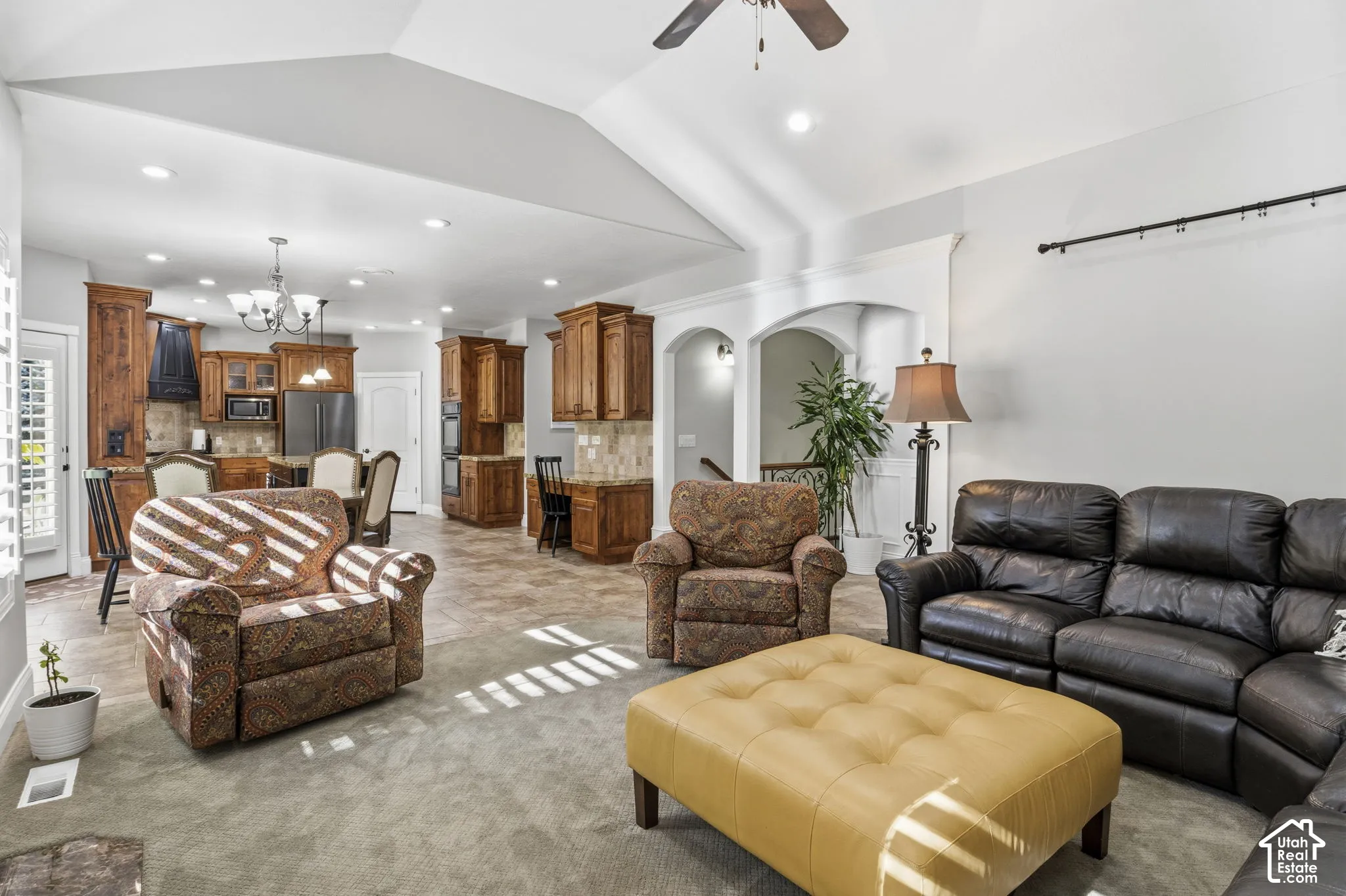 Vaulted ceilings, built-in cabinetry, recessed lighting, tile flooring, and arched architectural detailing