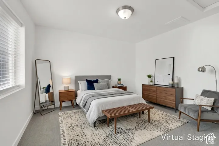 Neutral-toned room featuring wall-to-wall carpeting, crisp white walls, horizontal window blinds, and a circular flush-mount ceiling light fixture