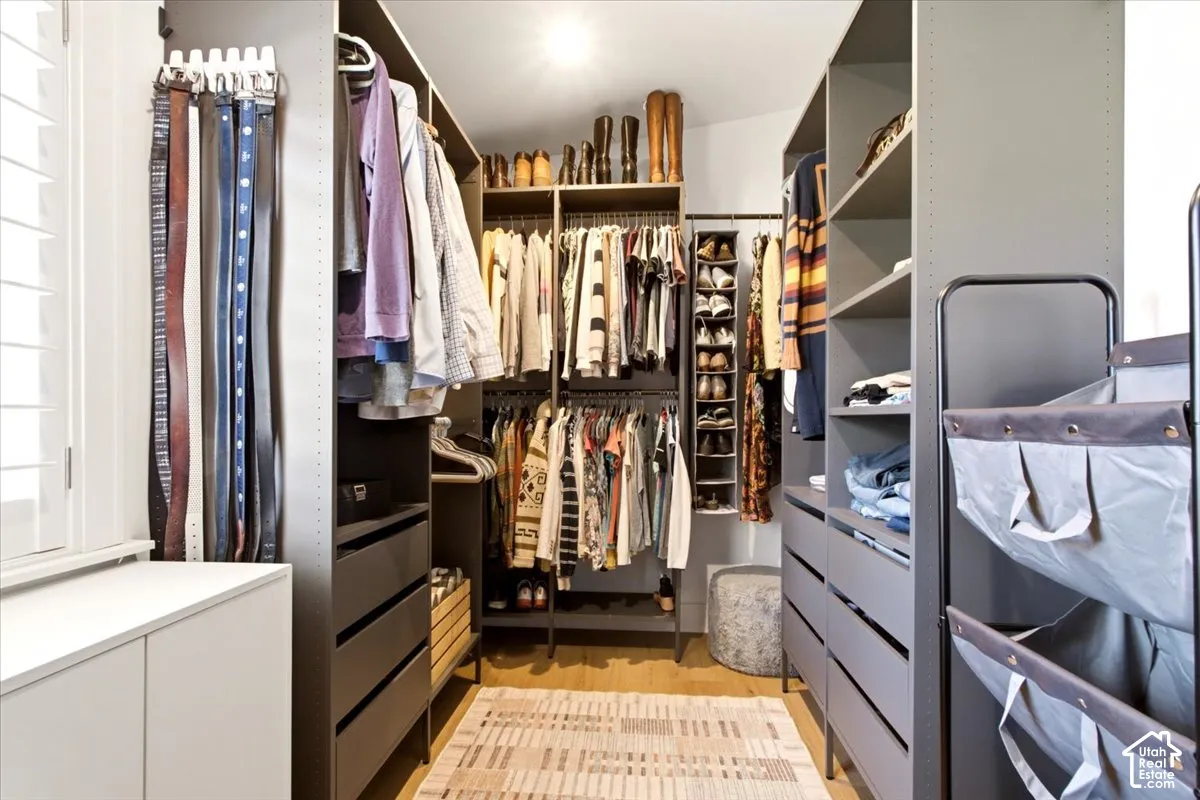 Custom walk-in closet featuring extensive dark cabinetry, built-in shelving, integrated drawer units, and hanging rods