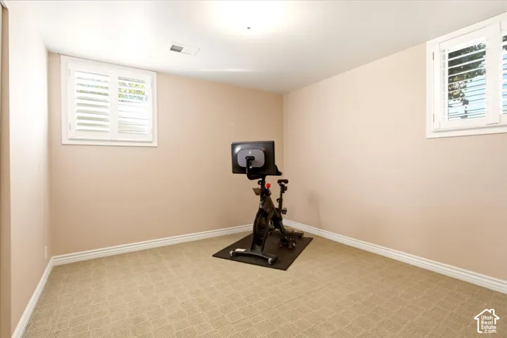 Interior room featuring wall-to-wall carpeting and dual windows outfitted with white plantation shutters