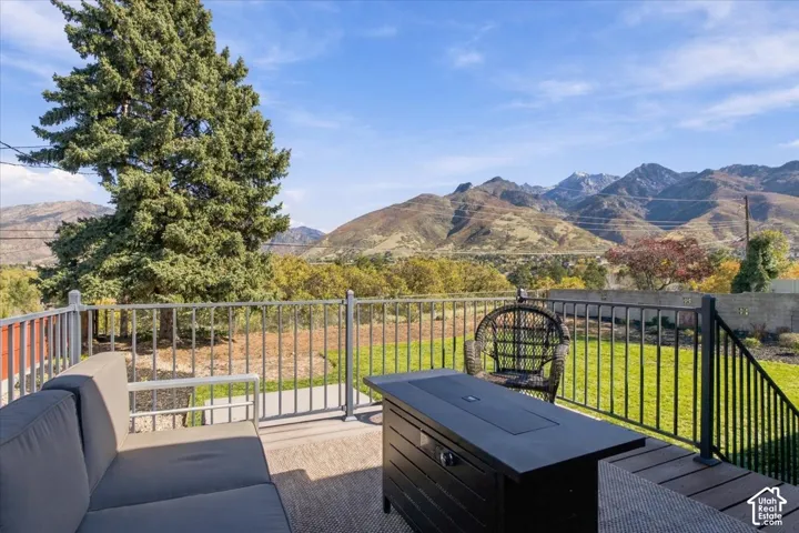 Elevated deck featuring composite decking, metal railing, and a backdrop of mountain scenery