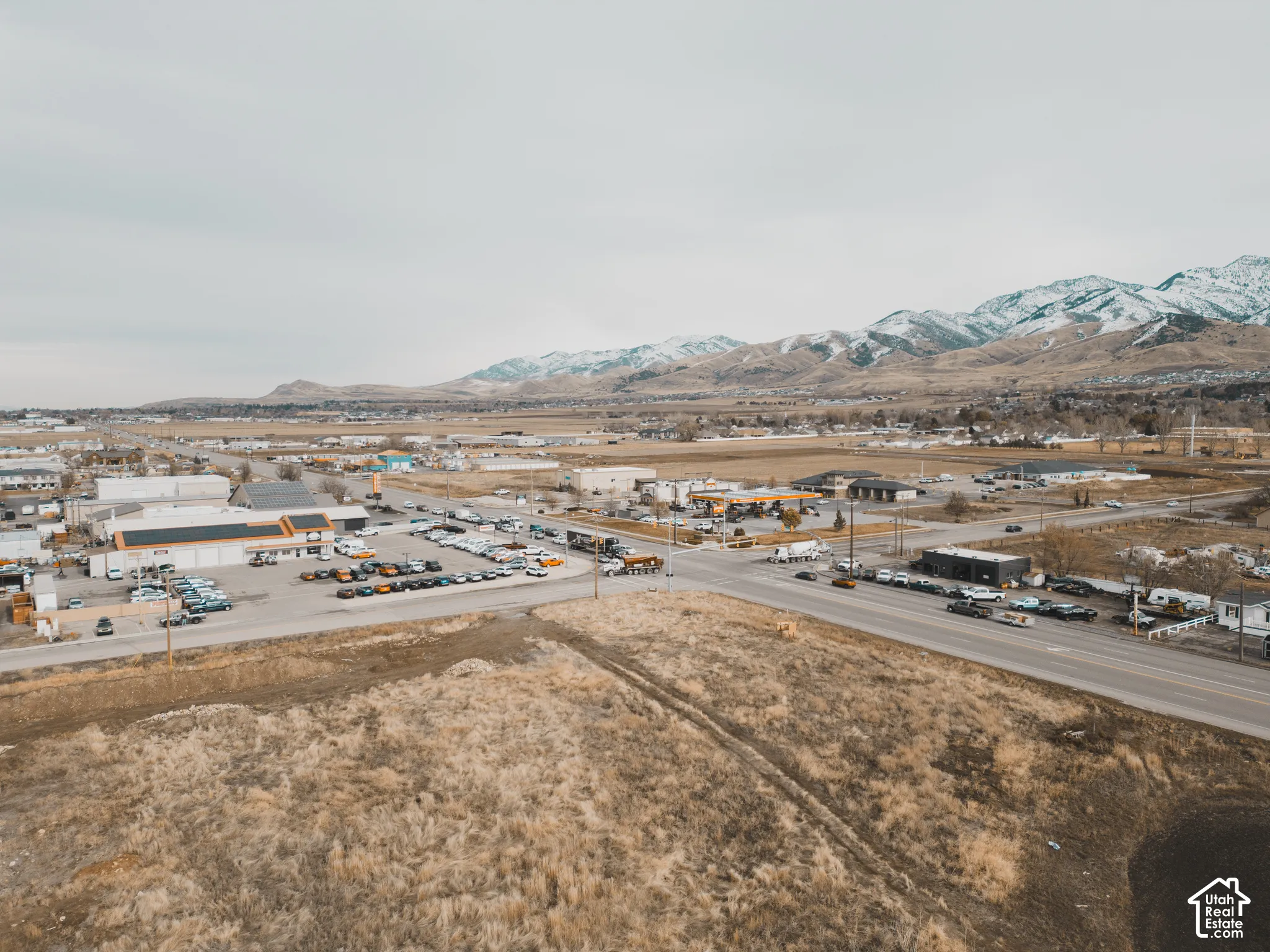 Expansive undeveloped lot with prominent mountain range backdrop and direct proximity to established commercial infrastructure