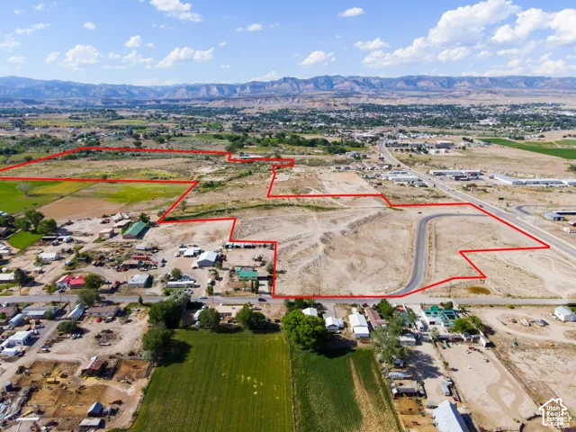 Expansive acreage with defined property boundaries featuring prominent mountain range backdrops